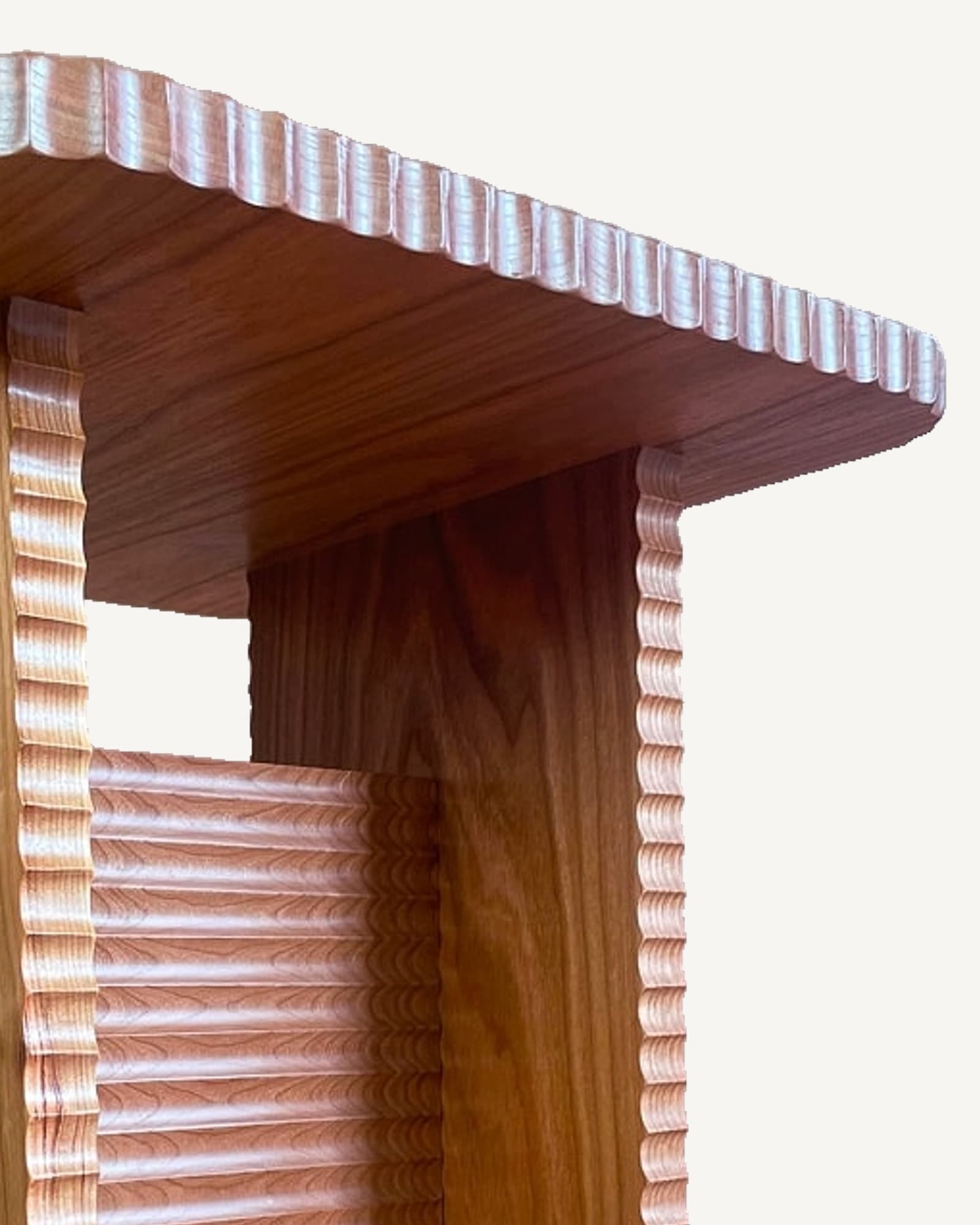 Cherry side table with carved fluted details on legs and projecting top edge, showing wood grain and natural warm
