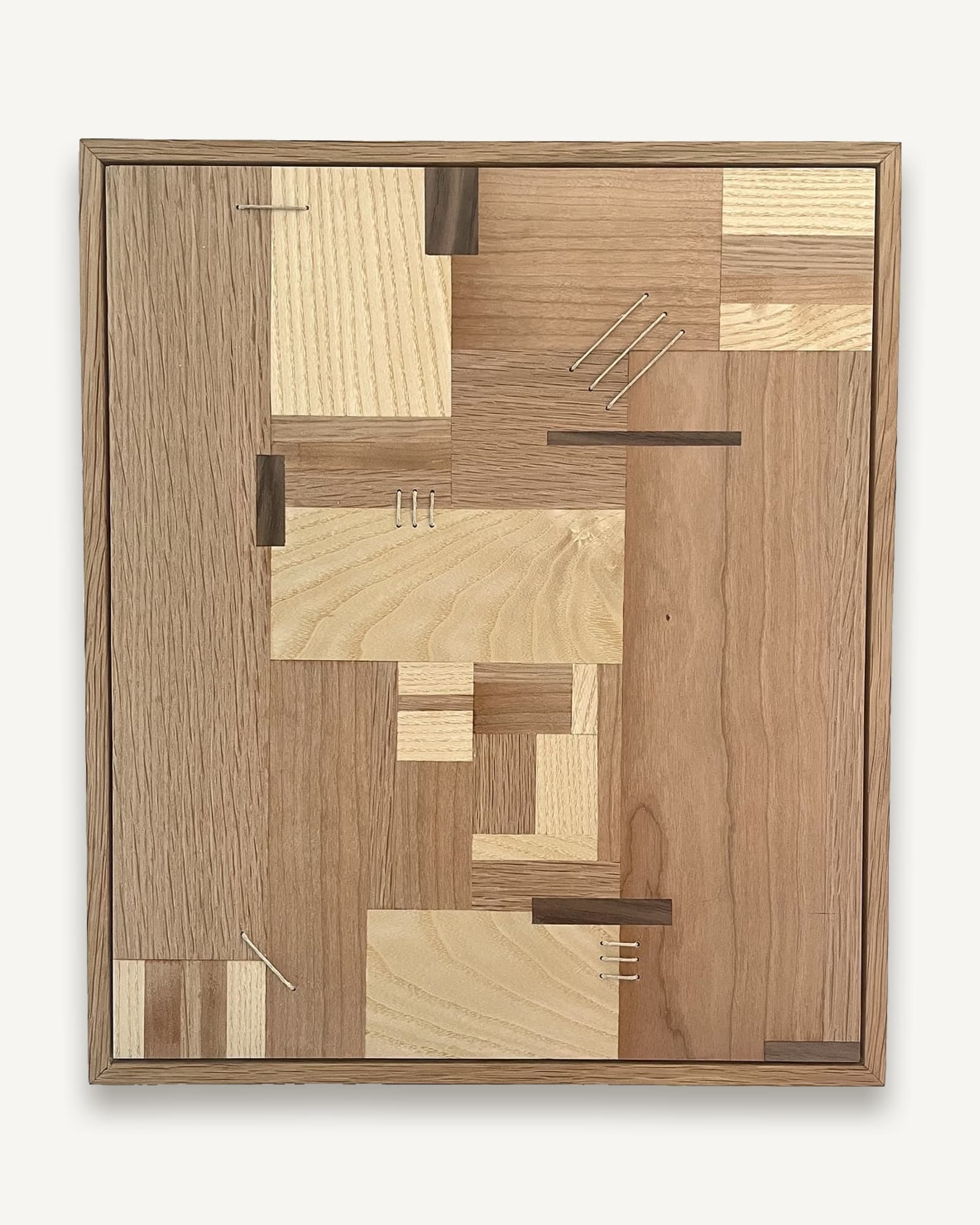 Framed wooden marquetry panel with geometric patchwork of oak, ash, cherry, walnut and sycamore in varying tones, accented
