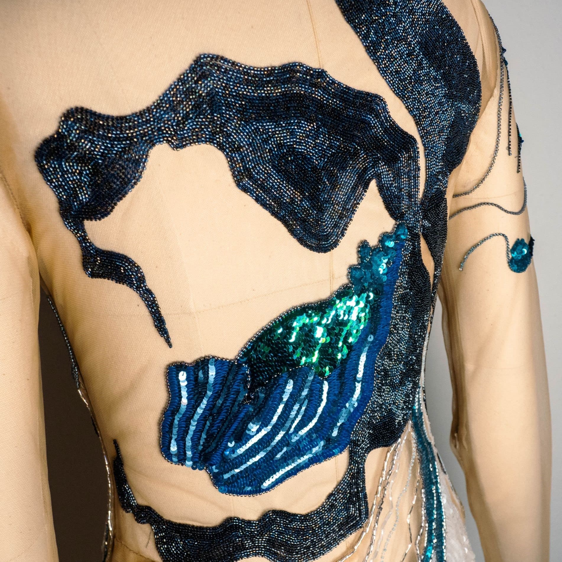 Side view of the couture dress showing orchid embroidery in sequins and beads over the hip
