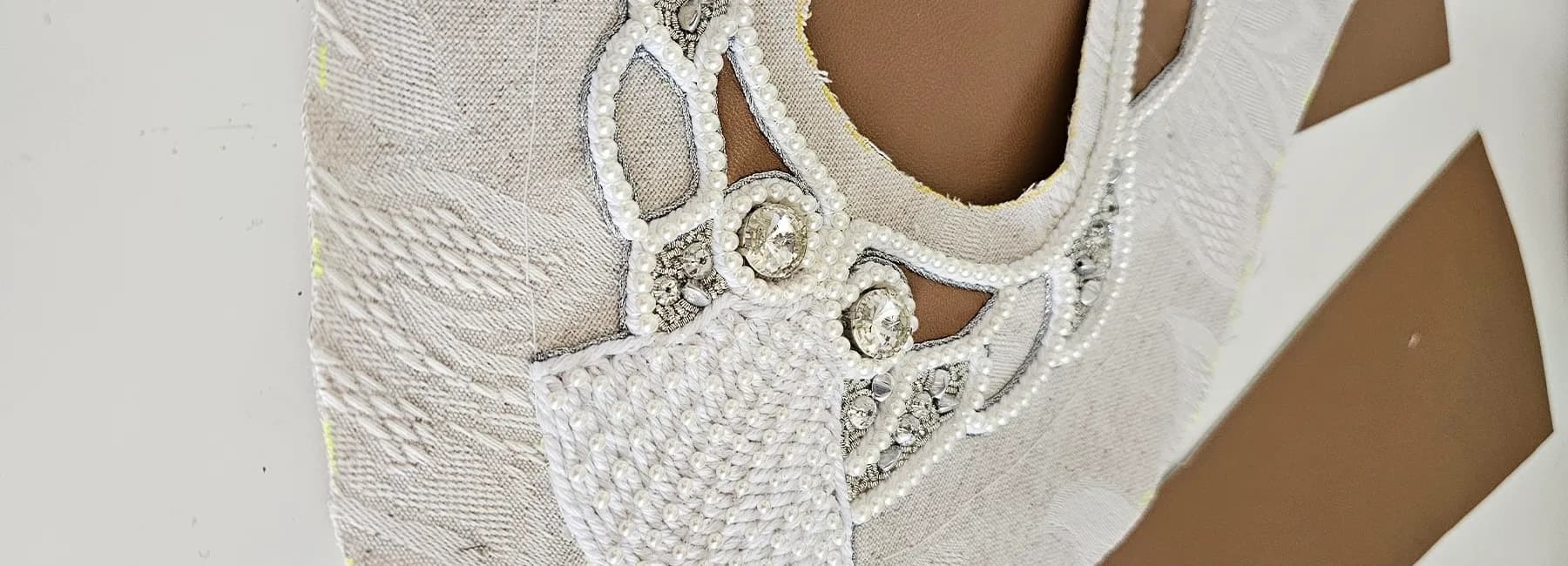 Close view of the shoe's openwork pearl embroidery over the toe
