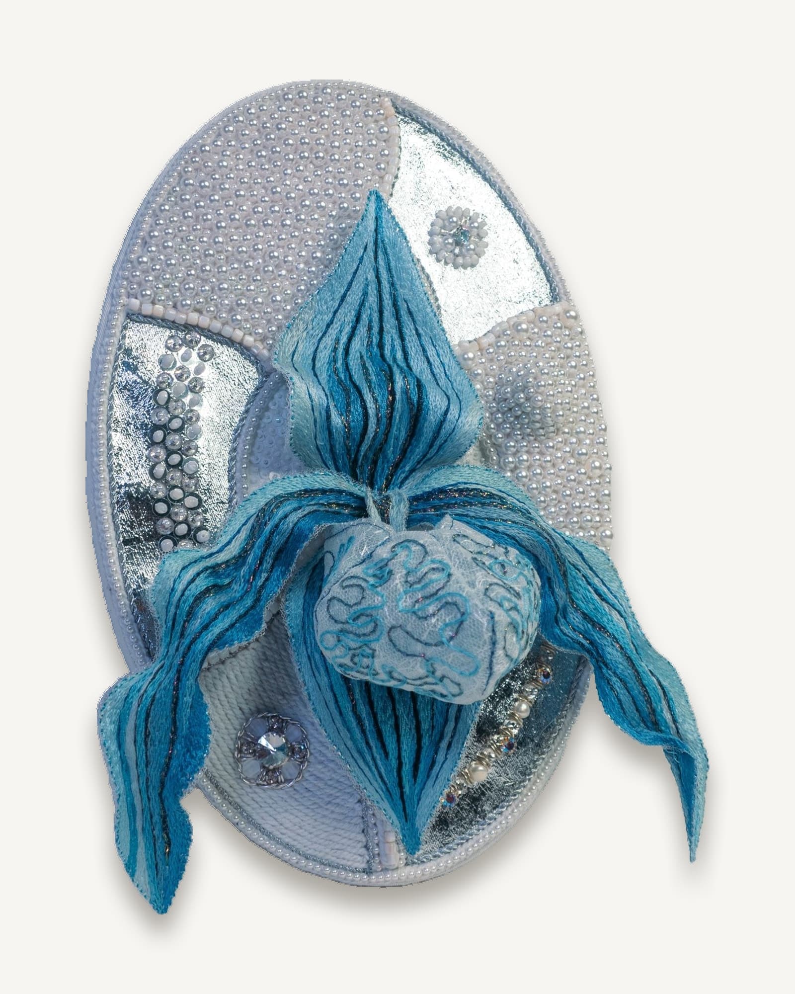Oval framed panel with a raised stumpwork orchid in blue and white on a pearl-set ground