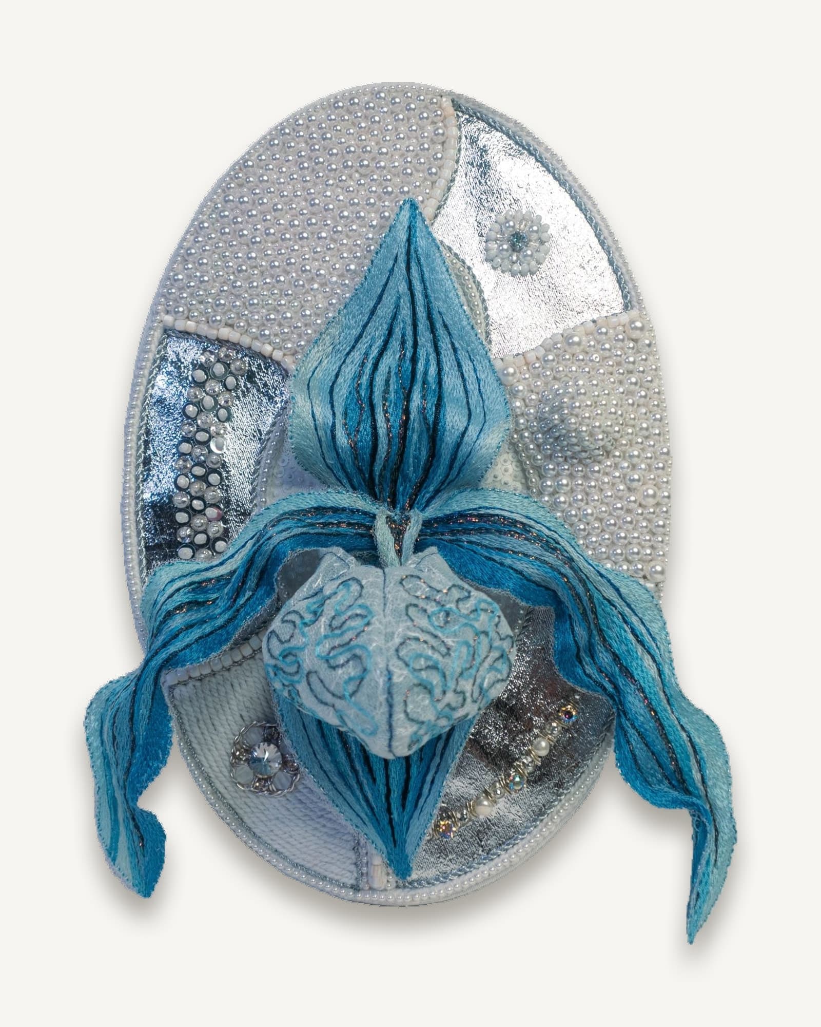 Detail of white cords and seed pearls worked in Russian pearl setting around the orchid