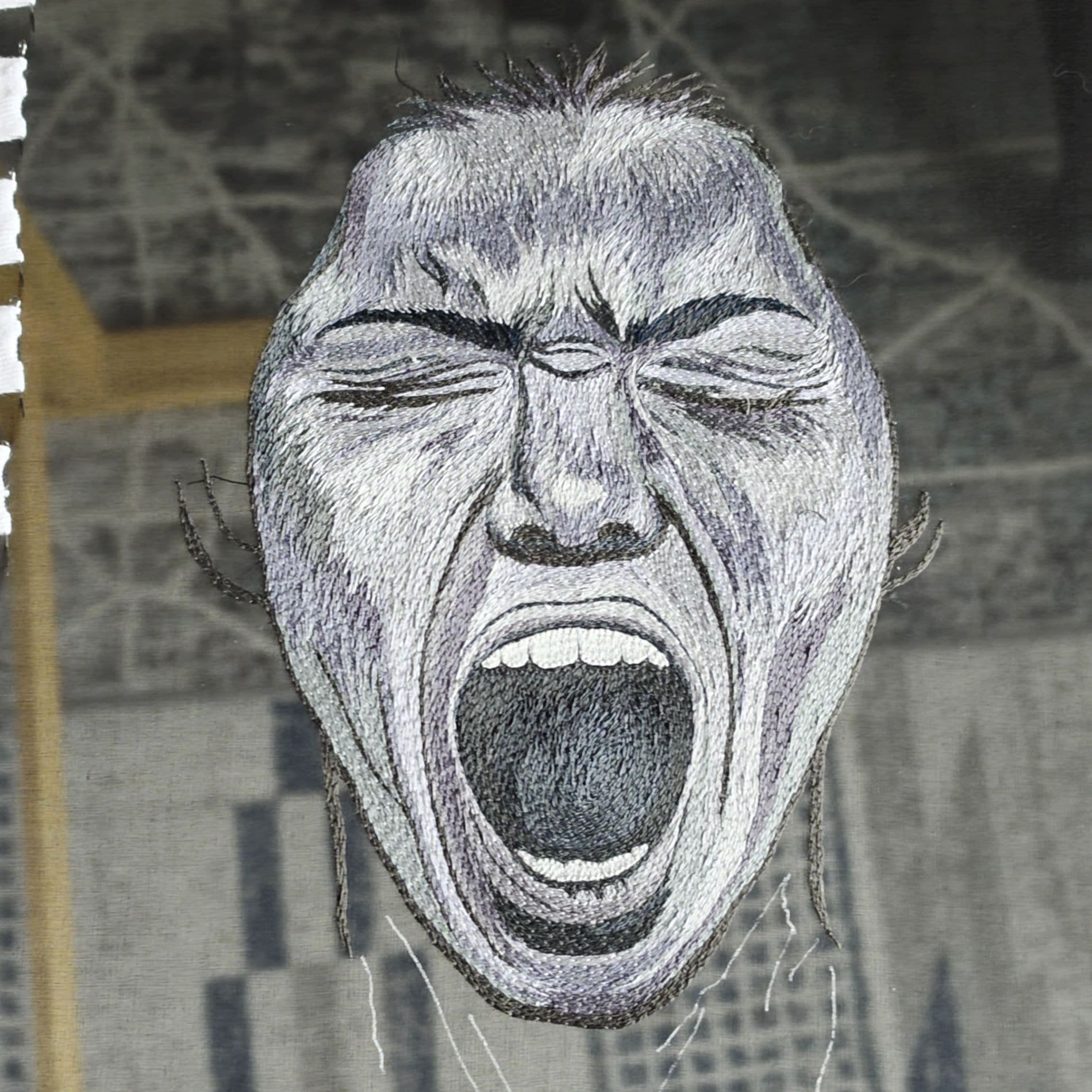 Embroidered portrait of an open-mouthed face worked in fine white and grey thread