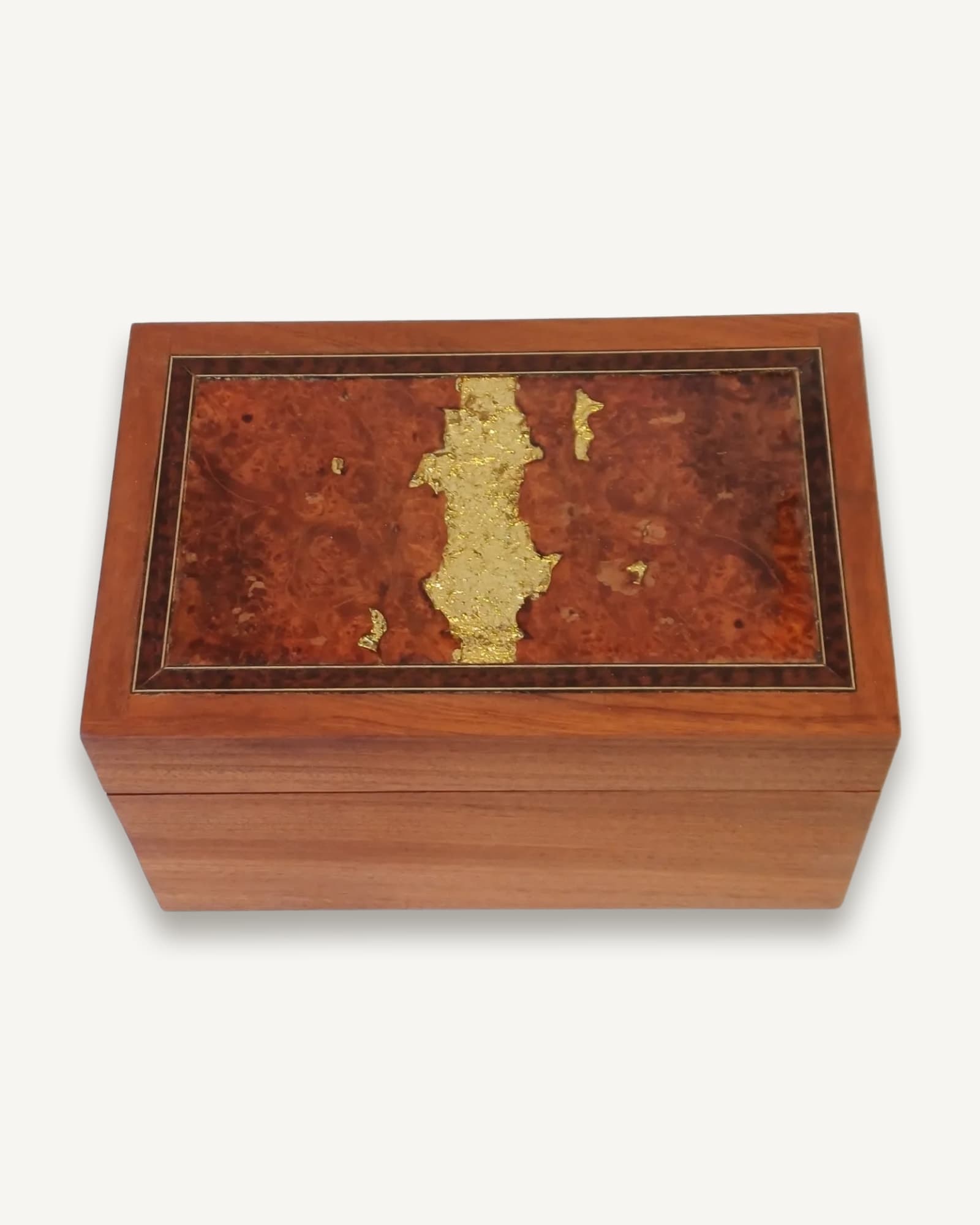 A cherry box with a burr lid, gold leaf laid into the figure of the wood and framed by fine dark and pale banding.
