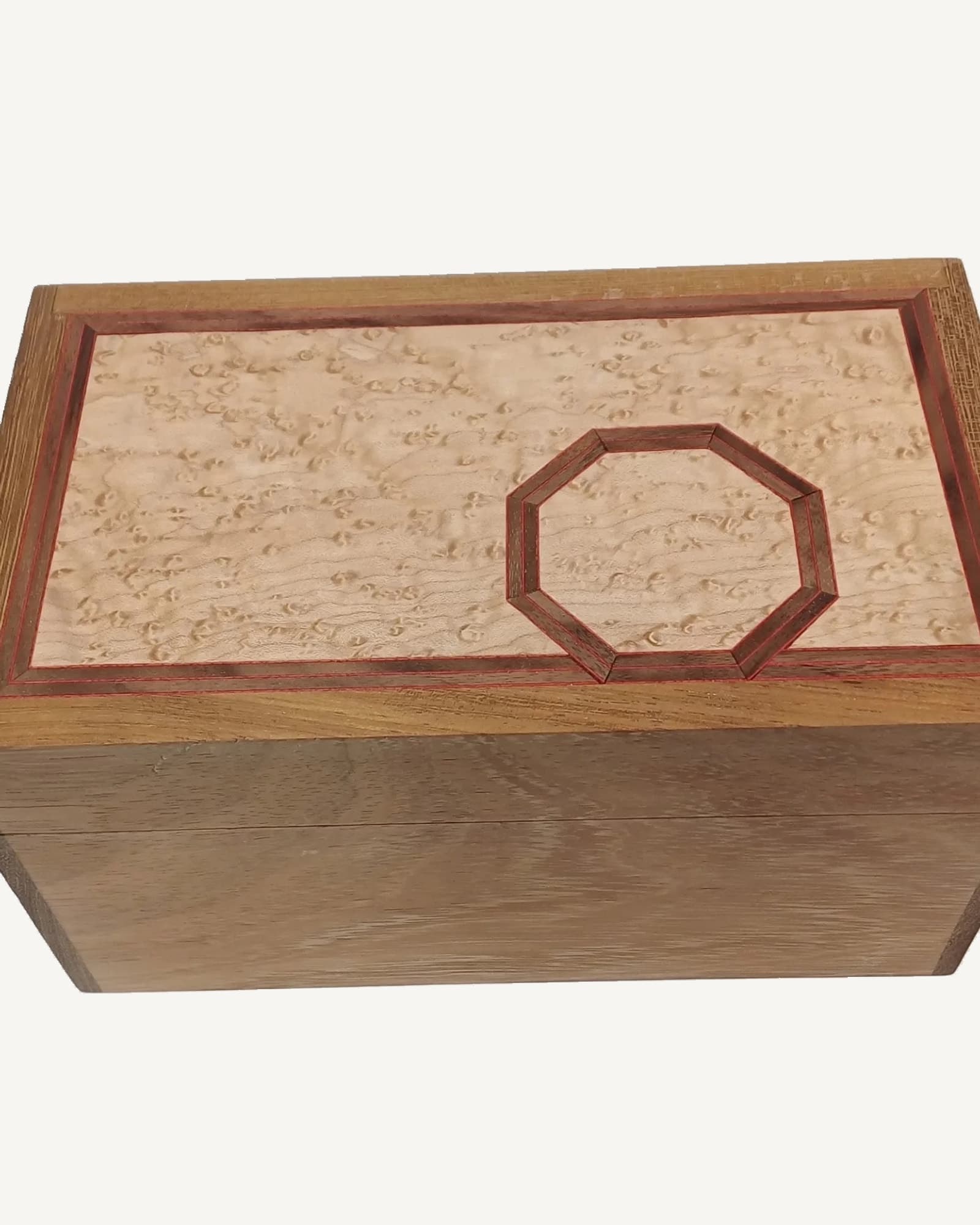 An oak box with a pale speckled maple lid, a single octagon outlined on it in banded inlay.
