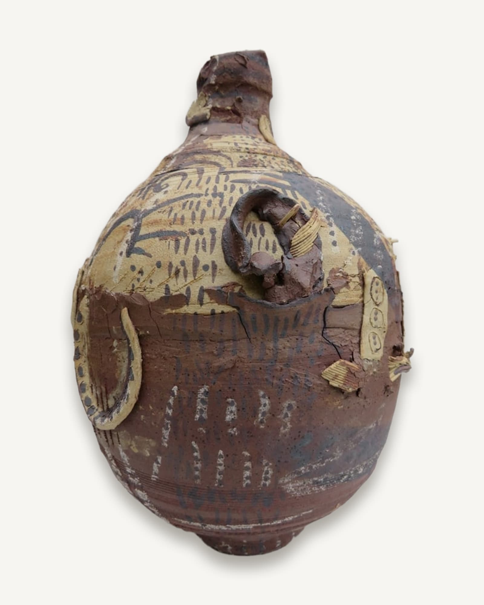 A wood-fired ceramic vessel with carved and slip-decorated surface