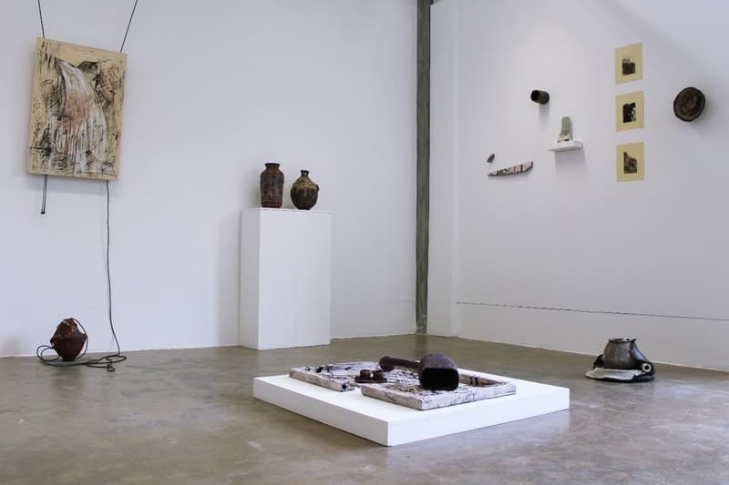 A gallery installation of ceramic wall panels, vessels and a floor piece
