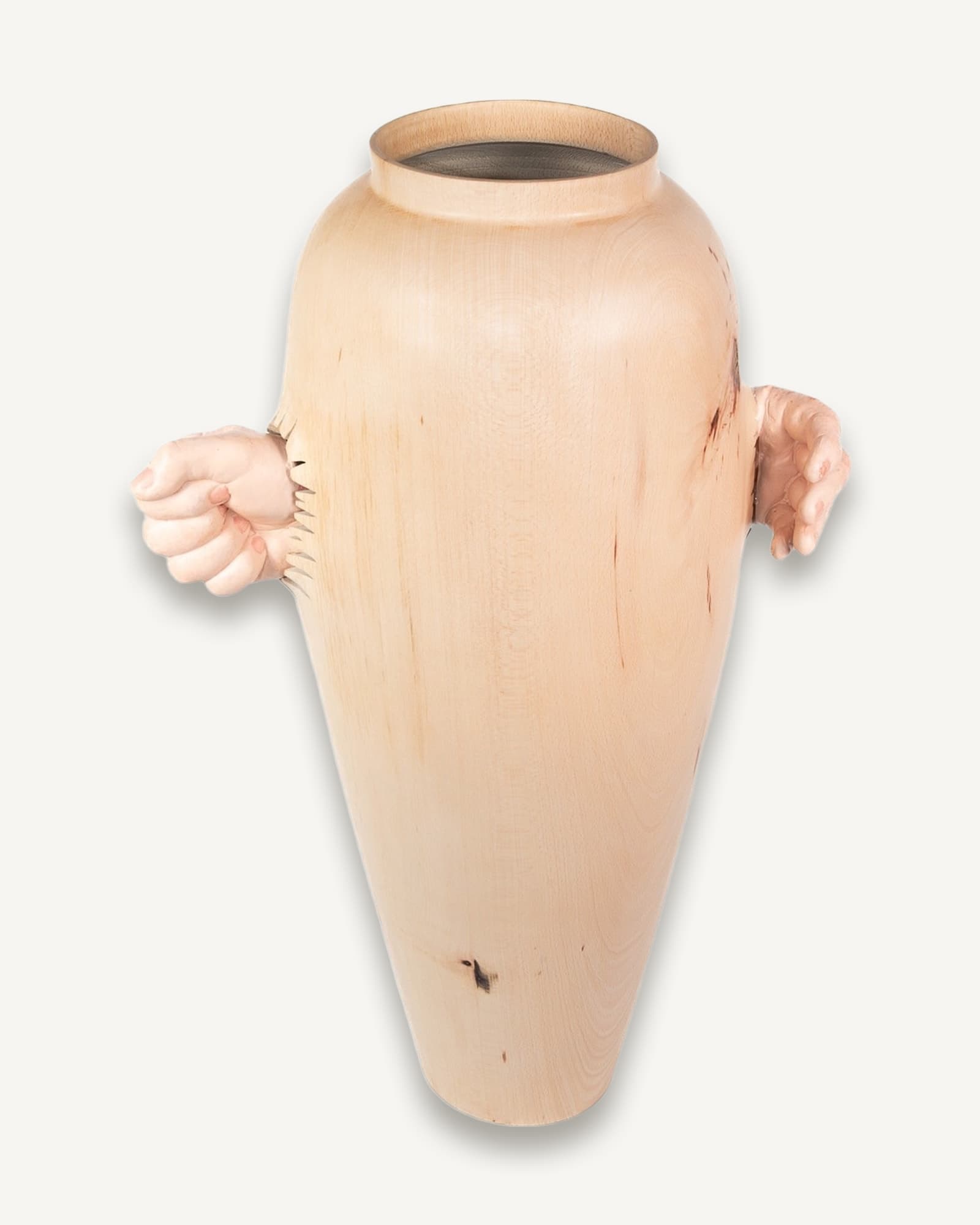 Tall pale beech vessel with dark rim, gripped by two cast hands emerging from sides, fingers carved with fine detail.