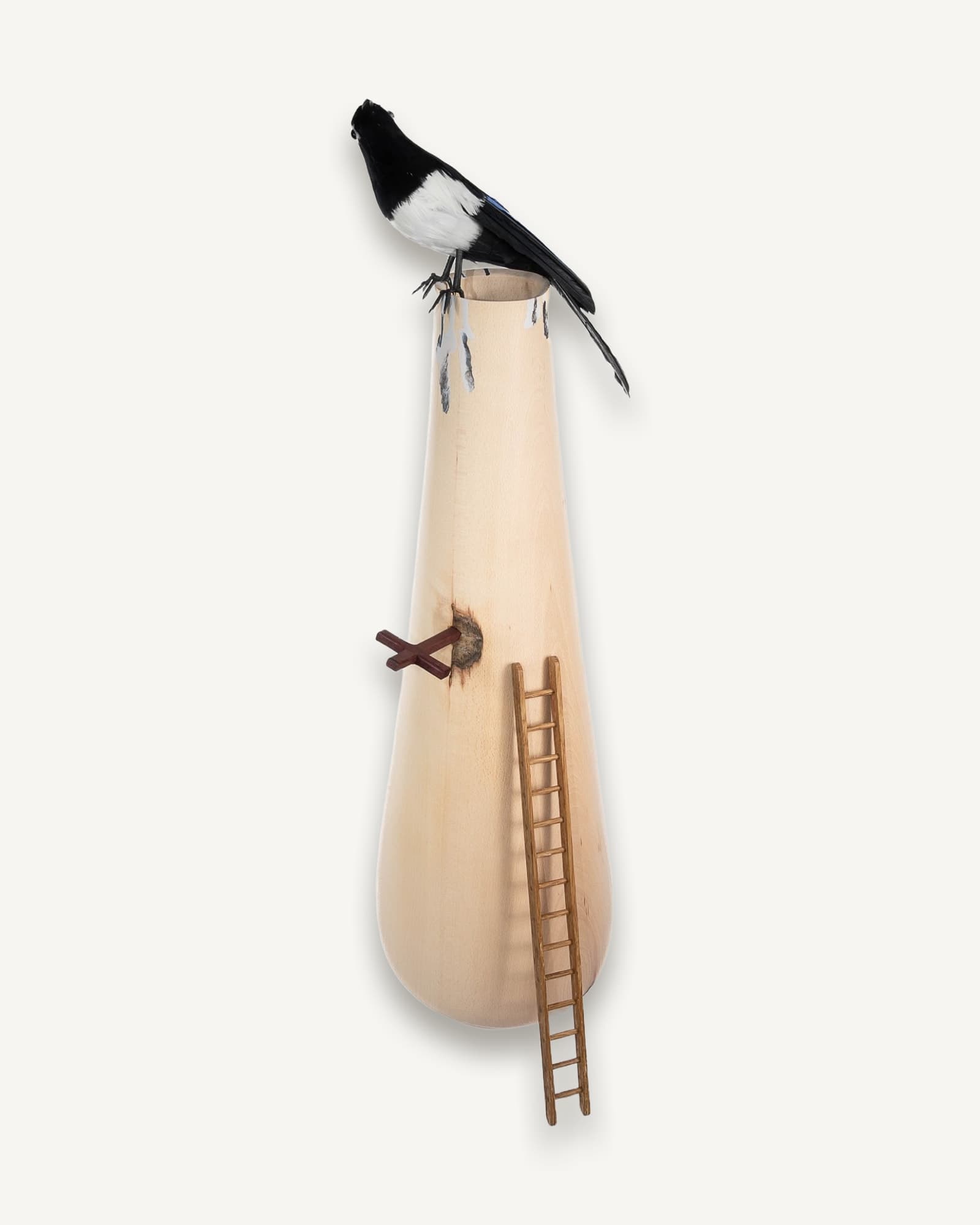 Pale beech vessel with black and white magpie perched on rim, wooden ladder leaning against side