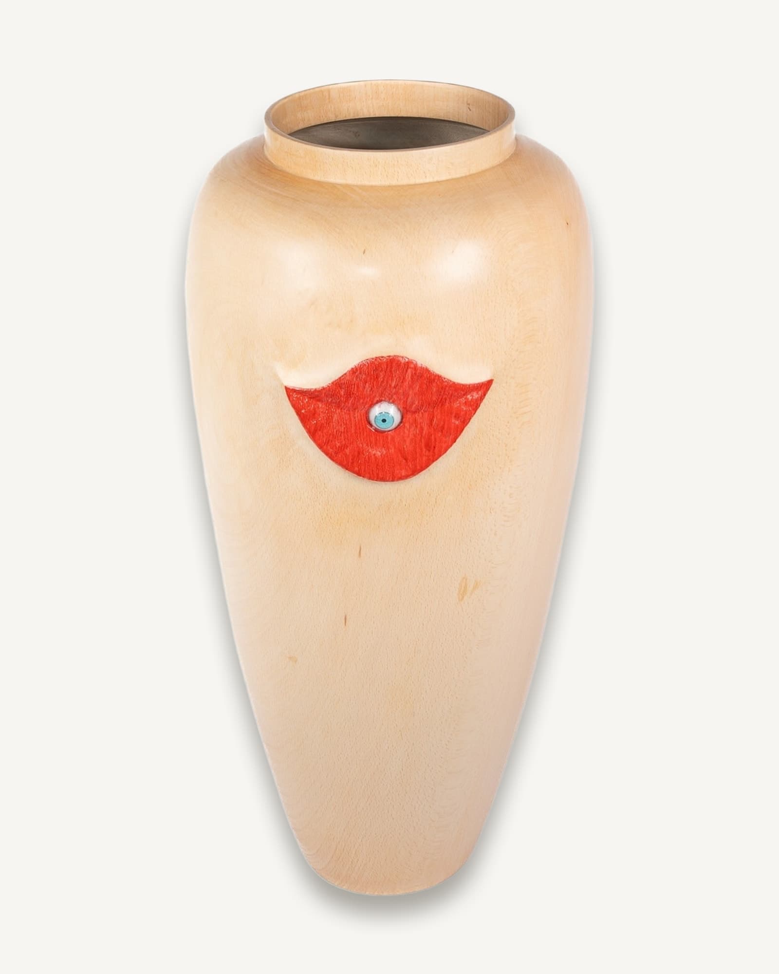 Pale wooden vase with red painted lips and a small blue eye detail at the centre.