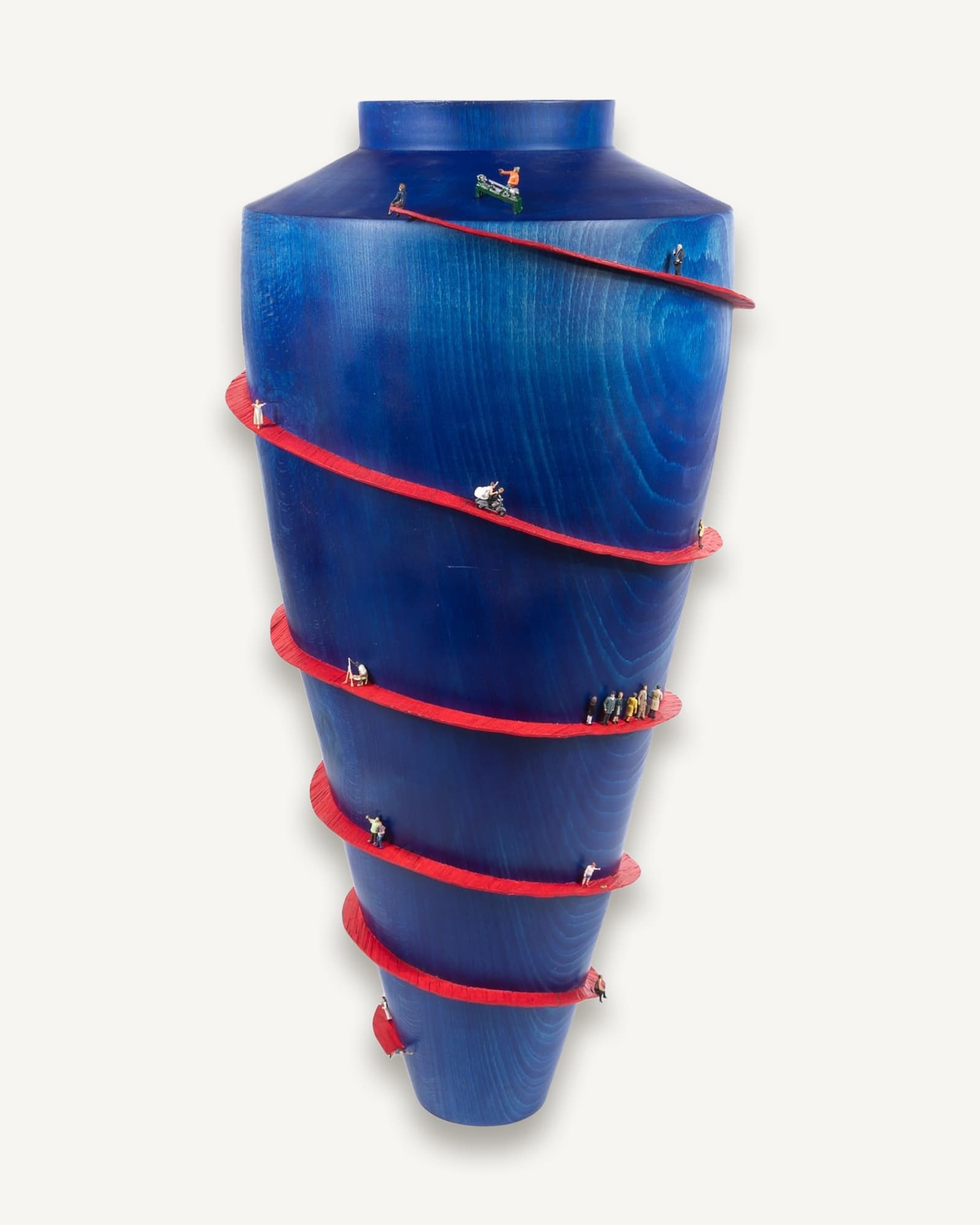 Deep blue conical vessel with red spiral thread wrapping around it, populated with tiny figures of people walking