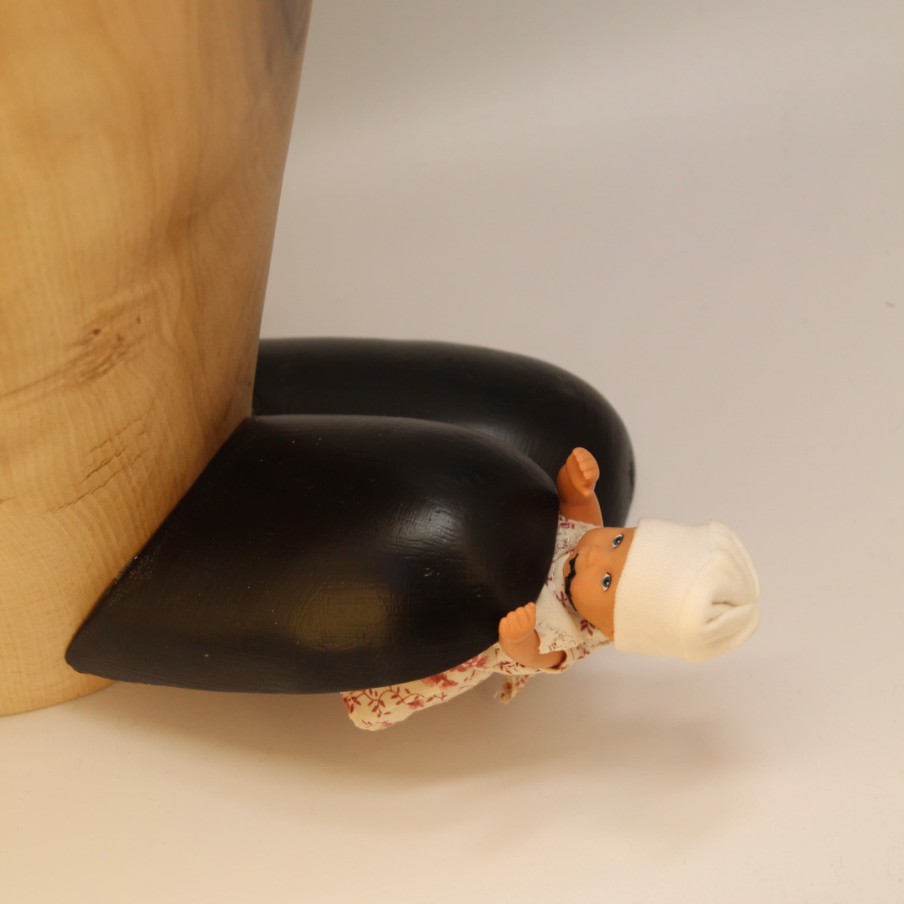 Beech vessel with two handles and natural black rot seam, small cloth figure lying in pooled rot at base