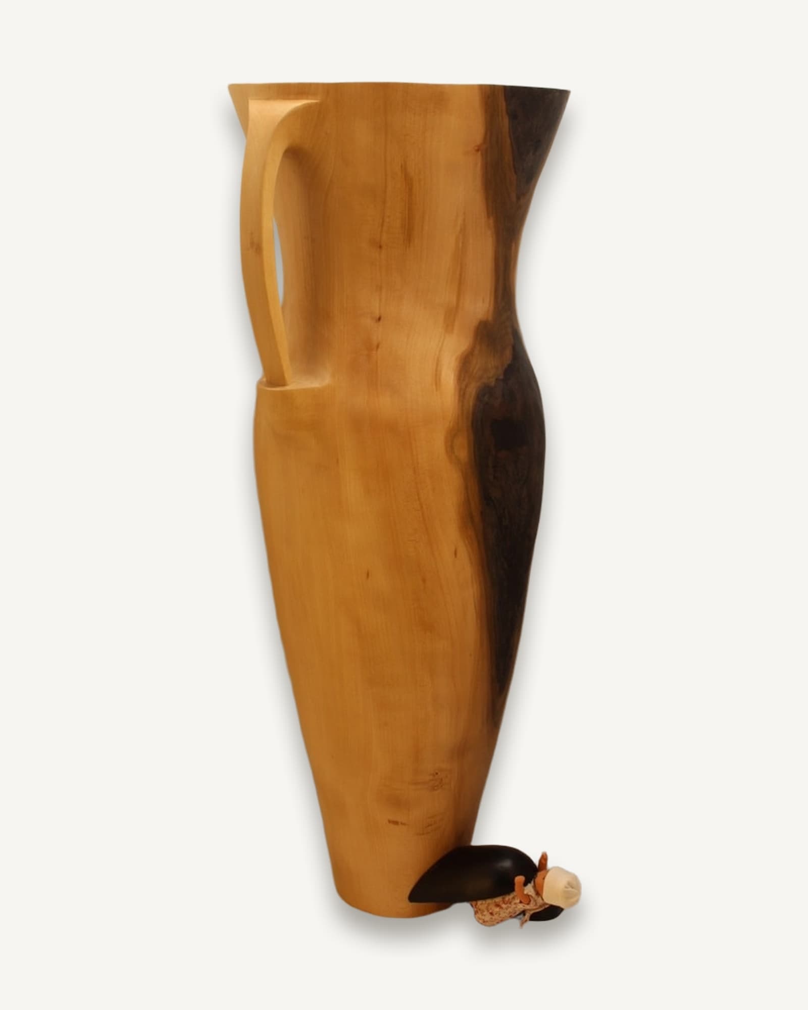 Tall beech vessel with curved sides and flared rim, honey-brown wood with black rot seam running its length