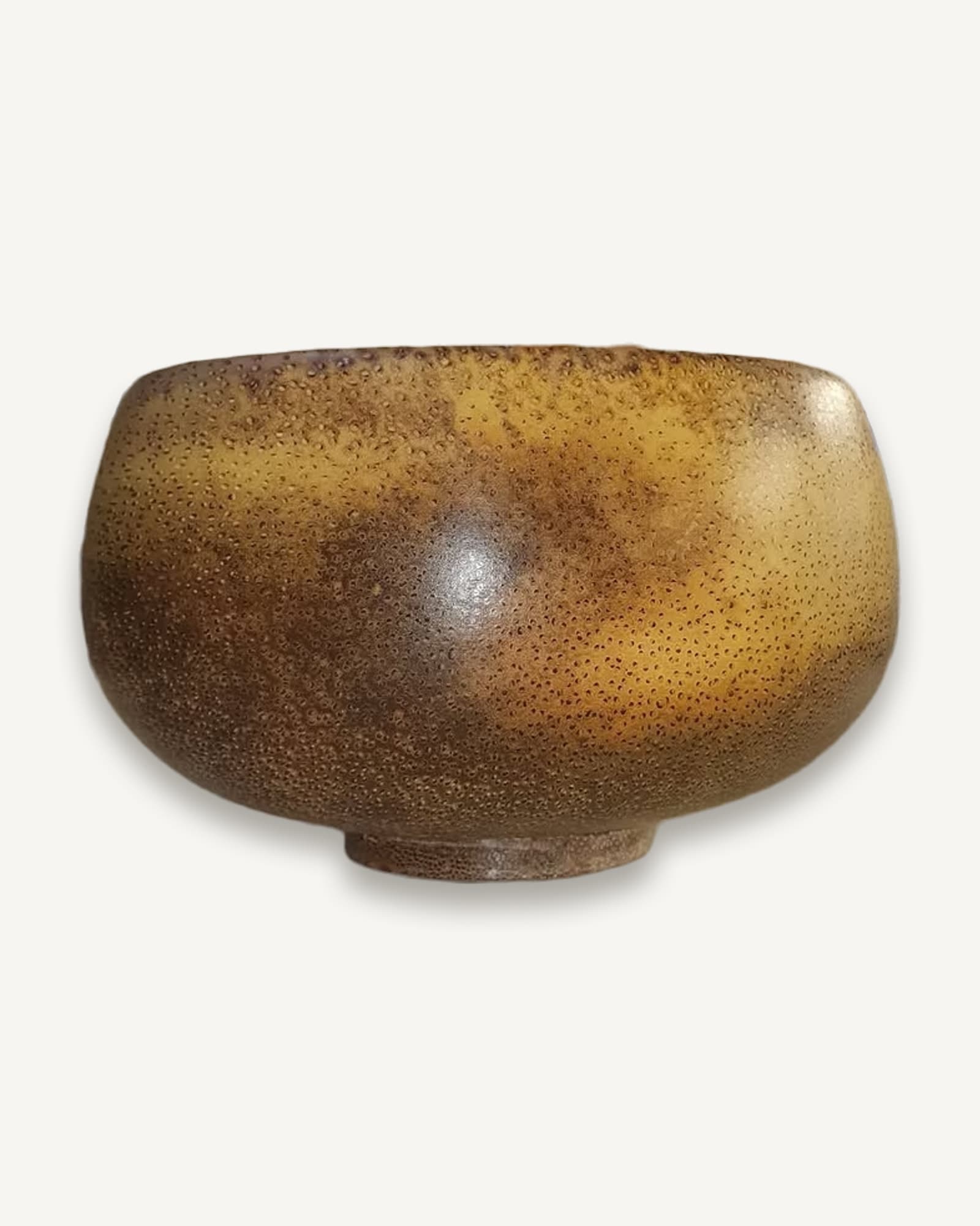 Rounded turned palm wood bowl with mottled gold and brown colouring from seasoning