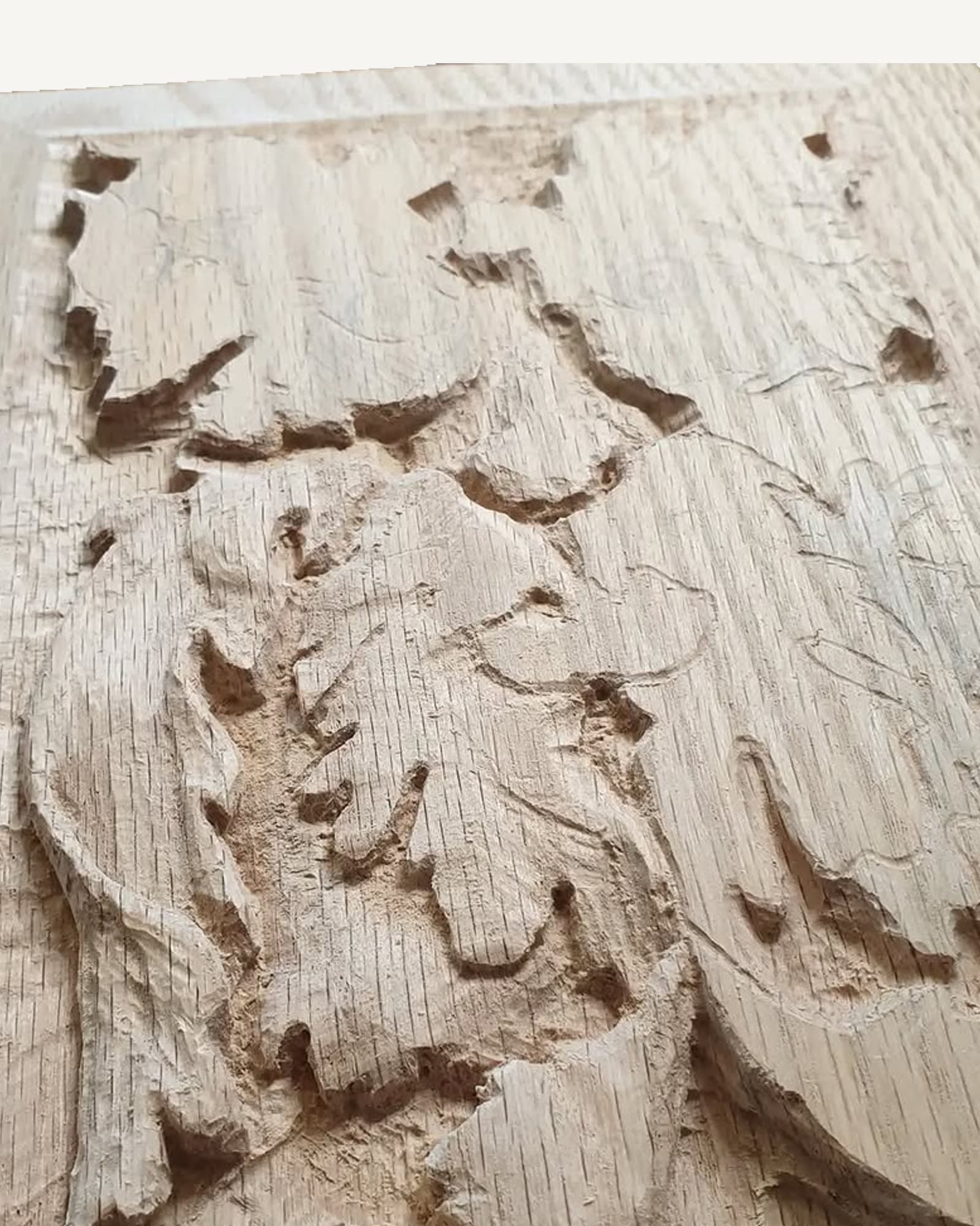 Oak leaves carved in relief across a quarter-sawn oak panel