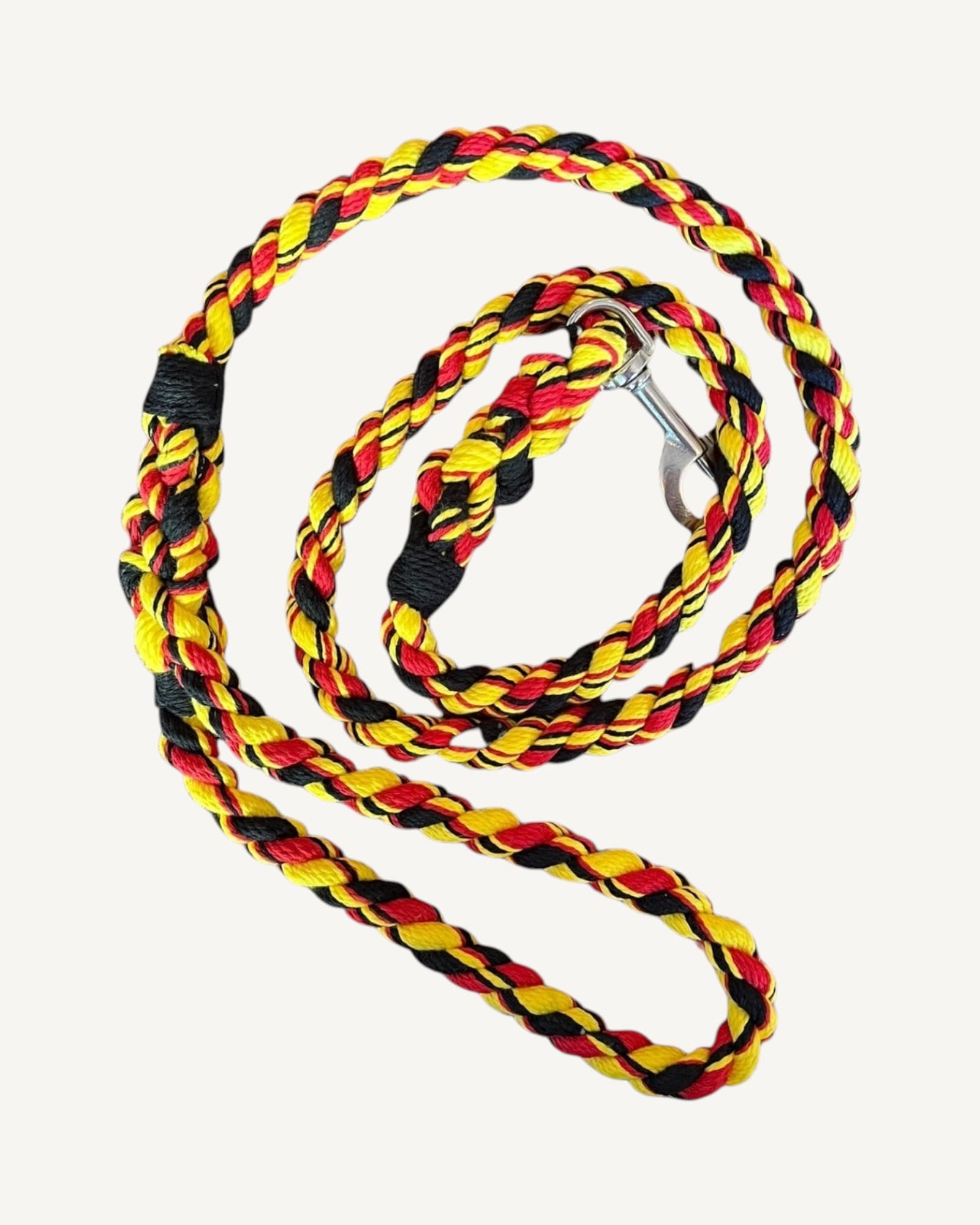 Coiled twisted rope leash in red, yellow and black strands with black wrapped grip section and stainless-steel clip