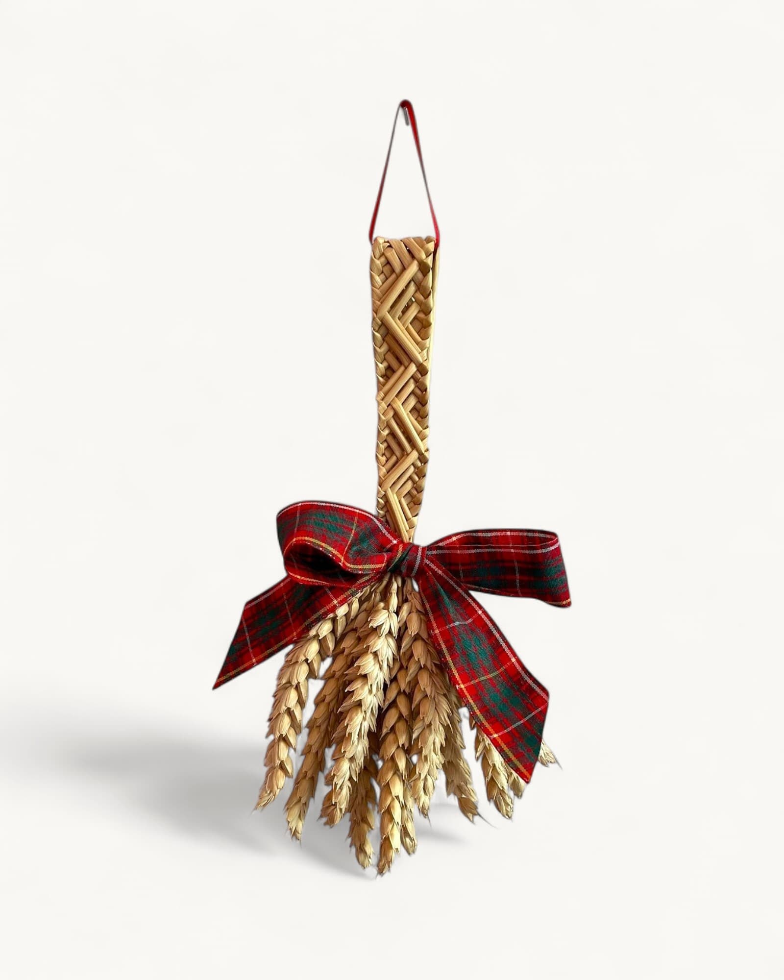Woven straw decoration in raised diamond pattern with burgundy tartan ribbon bow and hanging loop, golden wheat stalks