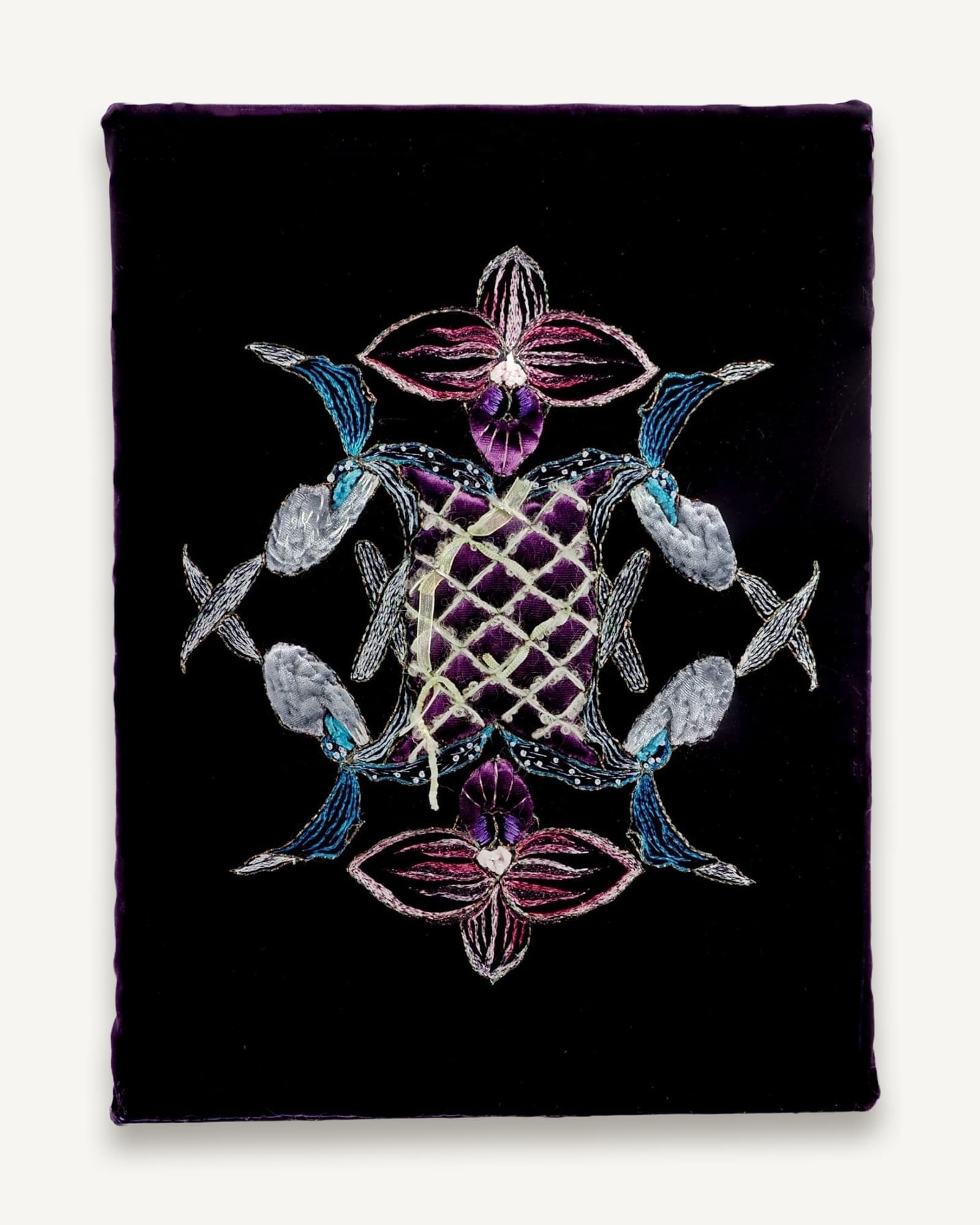 Symmetrical embroidered composition on black velvet featuring orchid flowers in purple, pink and white with blue