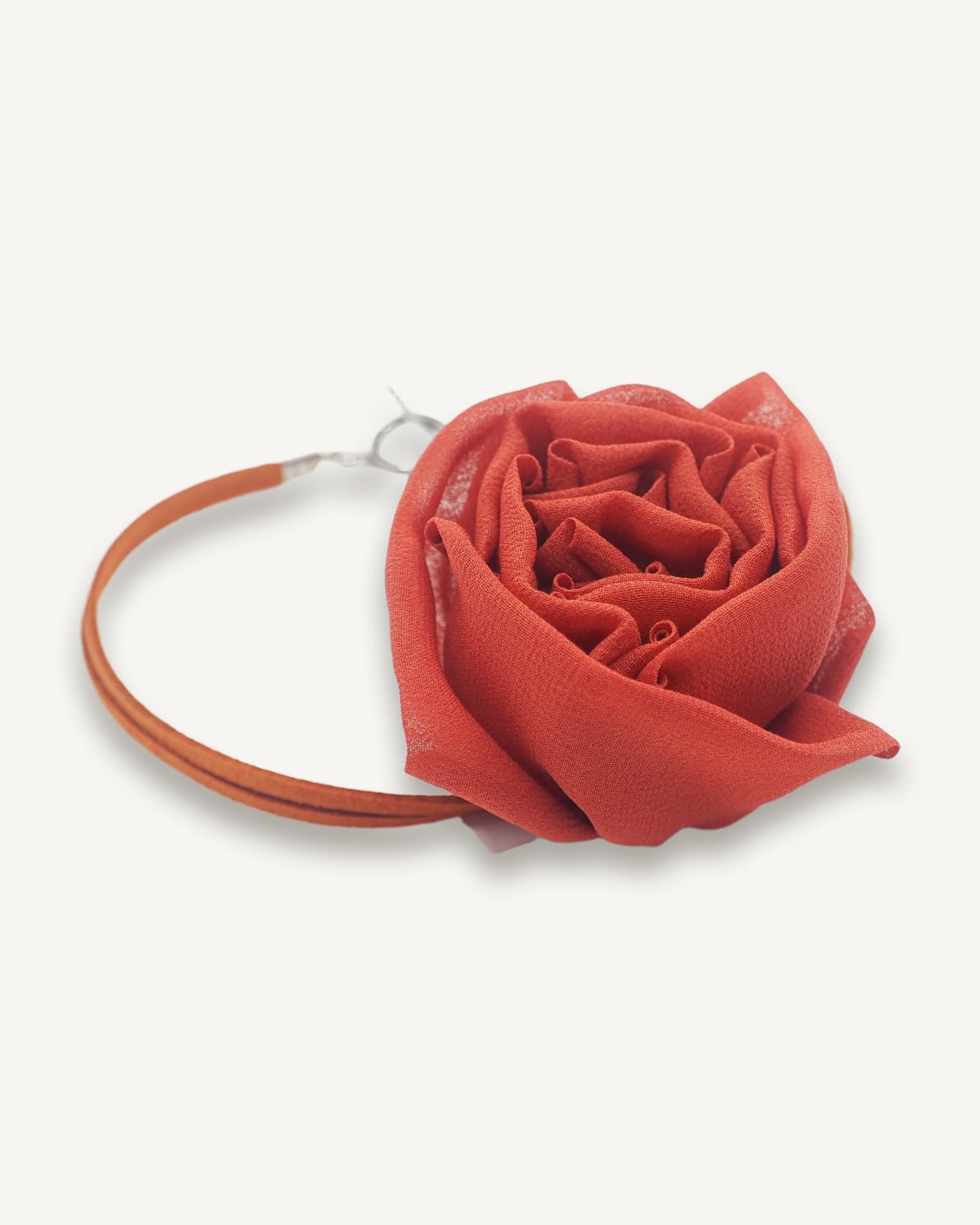Red silk rose bloom attached to matching fabric-covered choker necklace with metal clasp, displayed against white background.