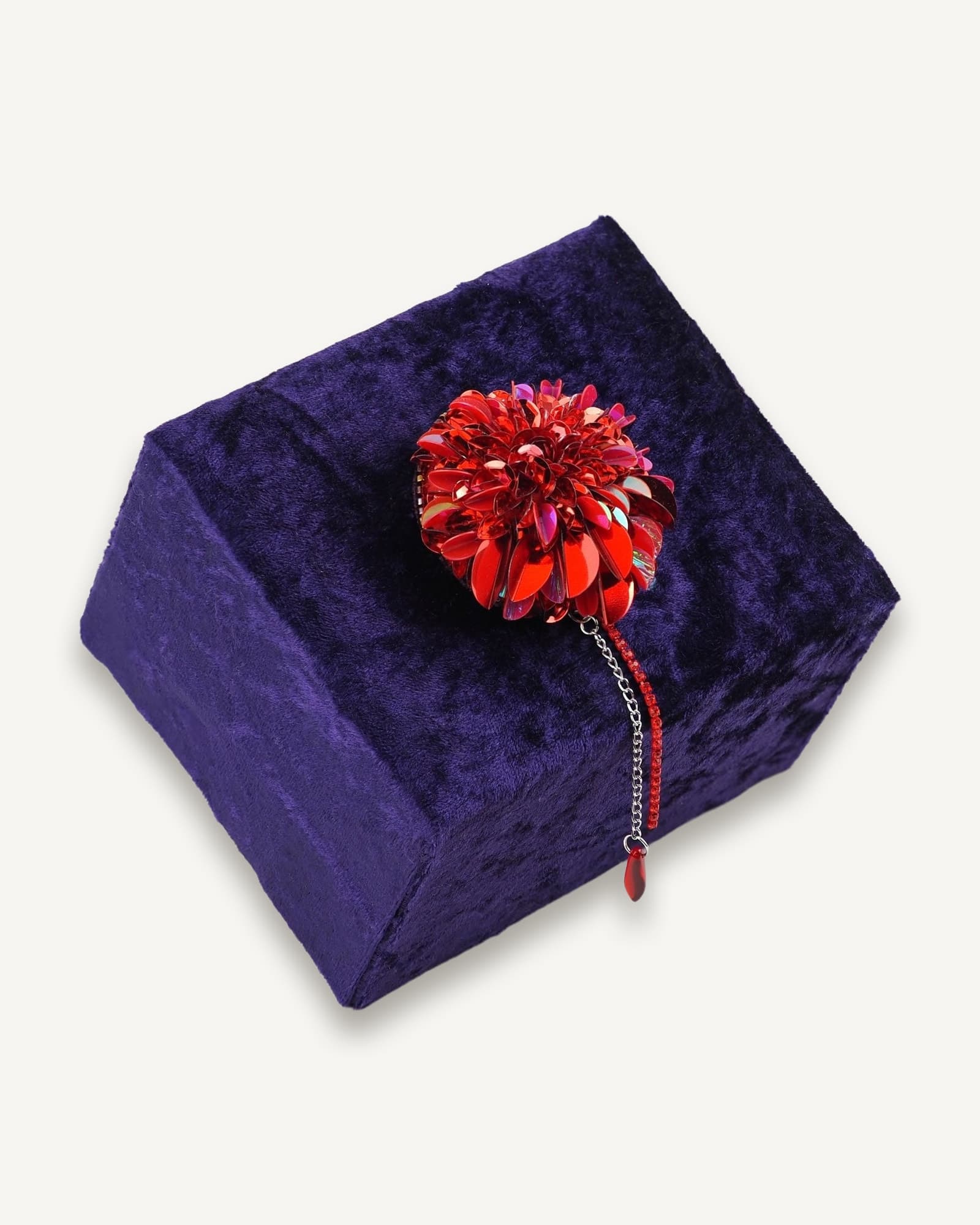 Handmade red dahlia brooch displayed on a dark velvet box, highlighting the intricate beading and limited edition design