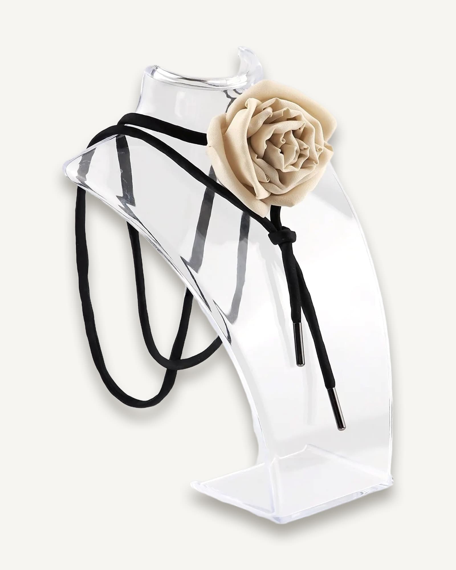 Nude silk rose choker by Ksenia Semirova displayed on a clear acrylic stand. This handcrafted accessory features a nude silk rose centerpiece, black satin lace, and nickel-free metal ends, highlighting elegant design and artisanal craftsmanship.