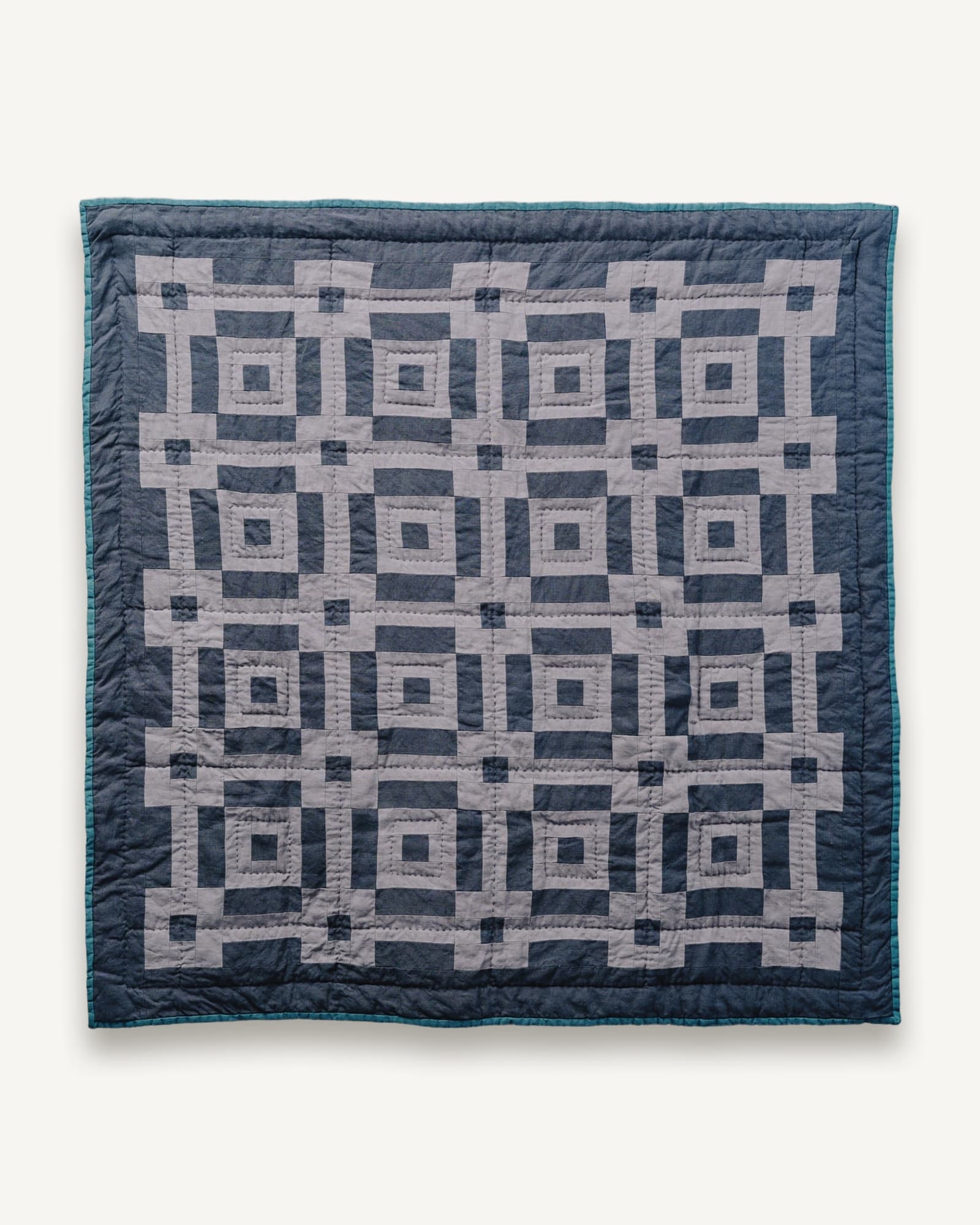 Blue and cream patchwork quilt with a geometric square pattern, hand quilted throughout