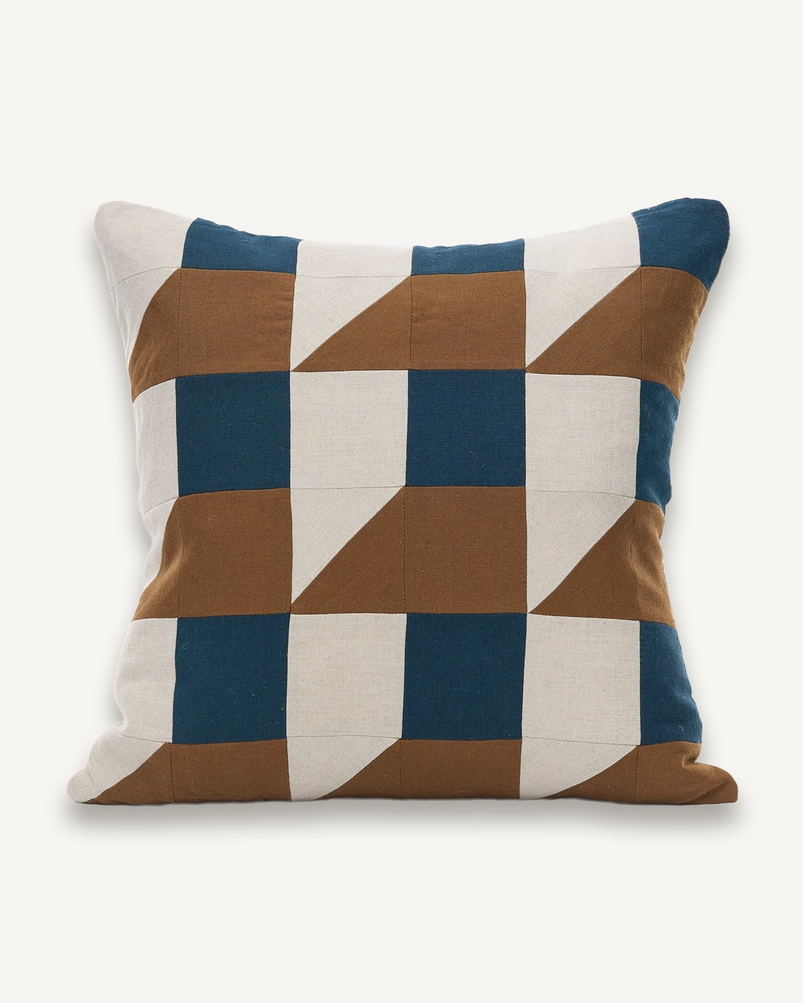 Linen cushion with patchwork blocks in navy, brown and cream forming a geometric checkerboard pattern