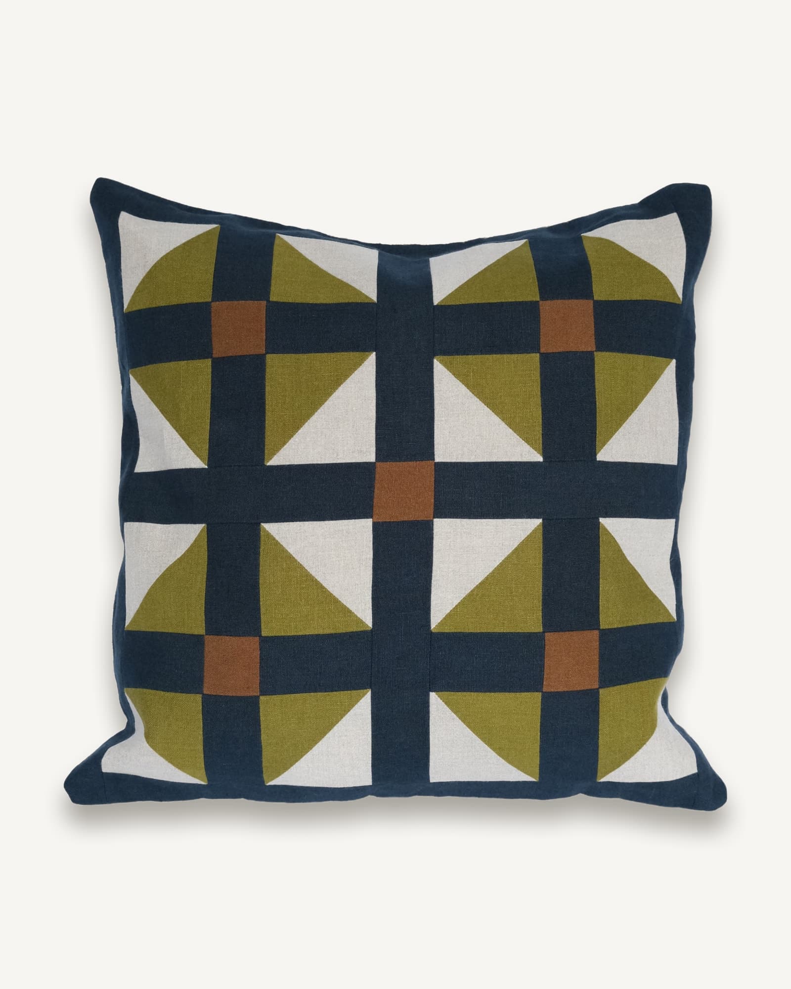 Navy linen cushion with a patchwork of tessellating tiles in olive, cream and rust