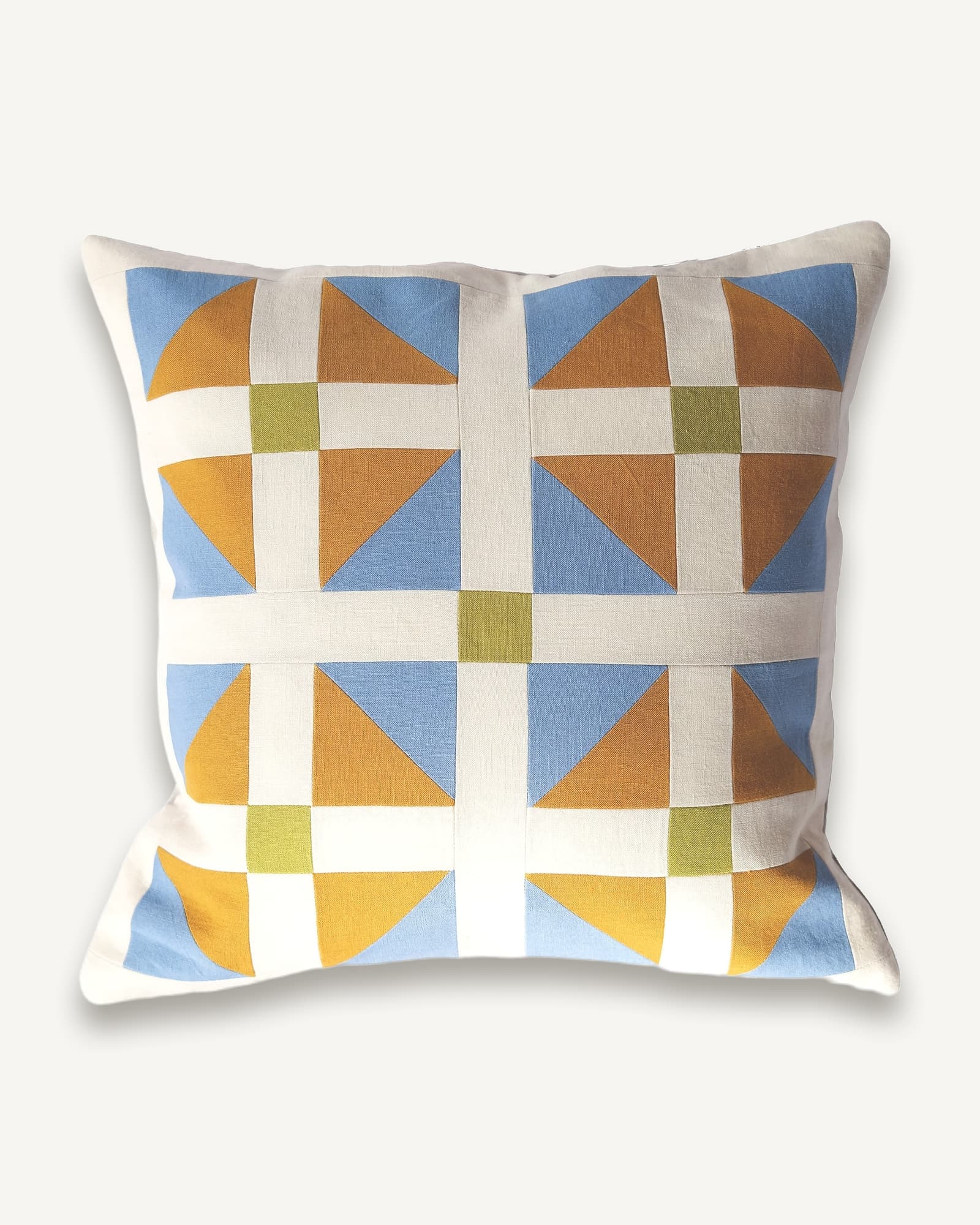Patchwork linen cushion with geometric tiles in blue, gold, brown and olive on a cream background
