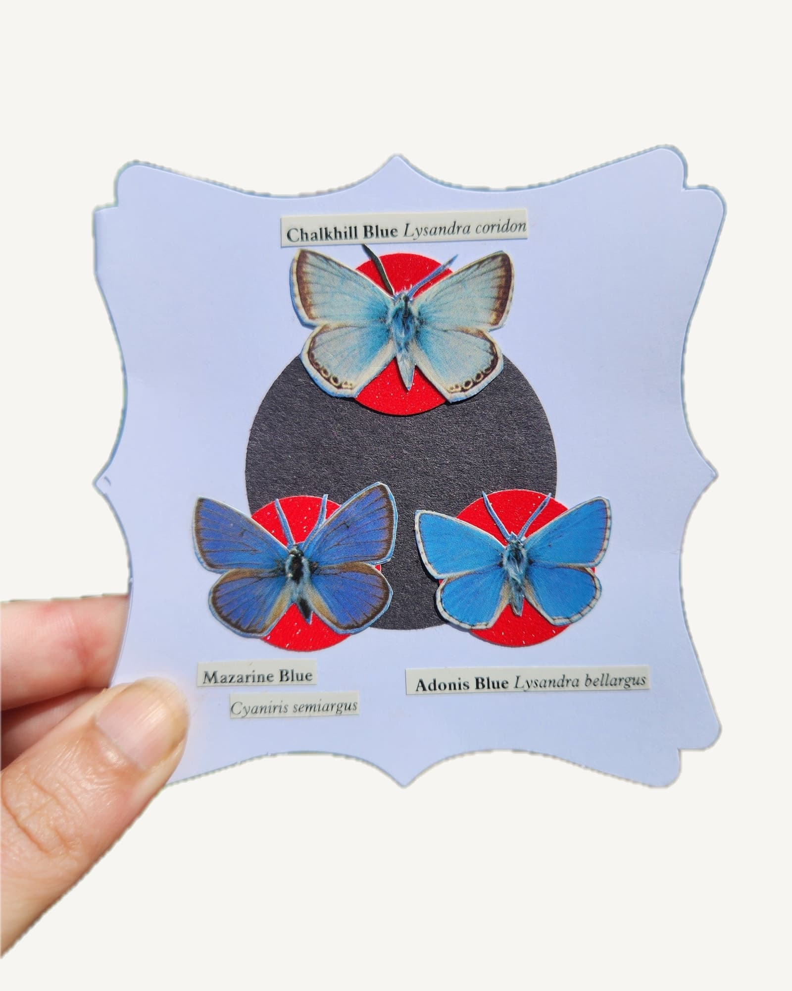 An original hand-cut collage of a group of small blue butterflies on a square card, made individually from thrifted paper.
