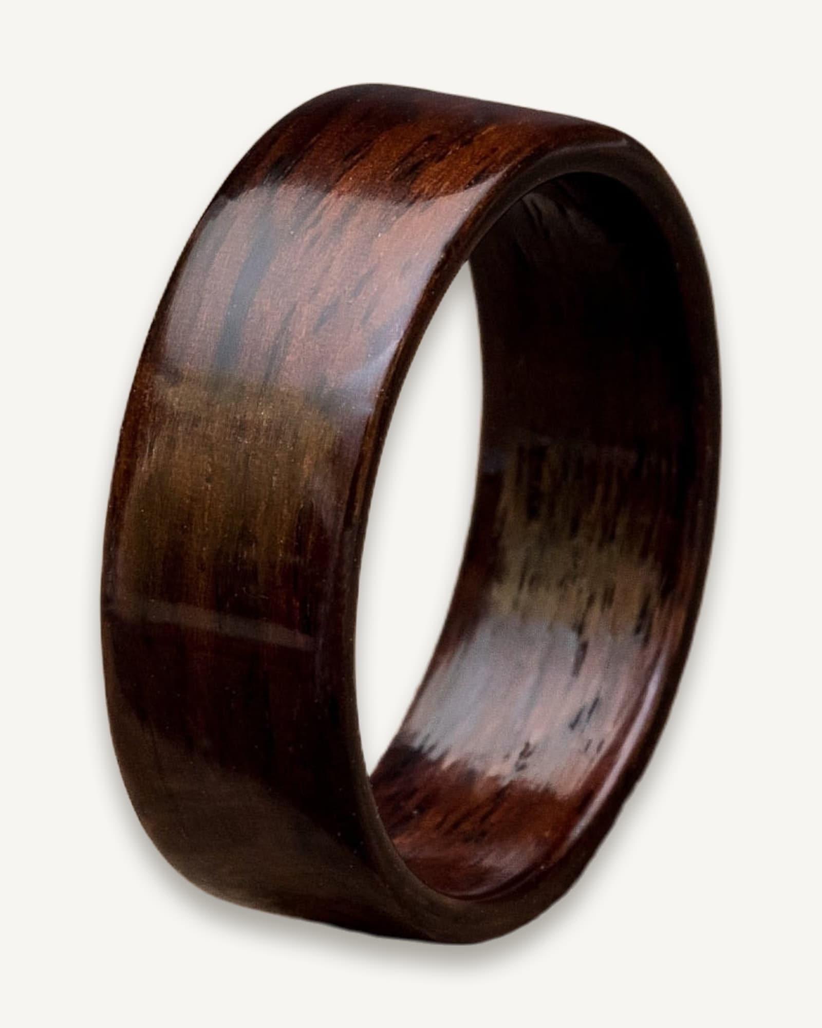 Deep reddish-brown bentwood ring with continuous grain pattern wrapping around its curved surface