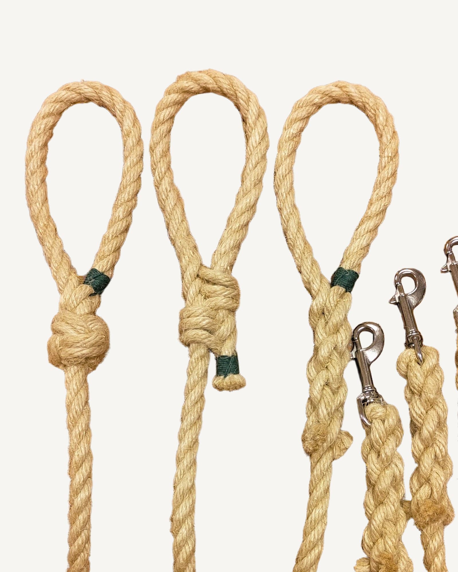Three natural flax rope dog leads with knotted ends and green thread details
