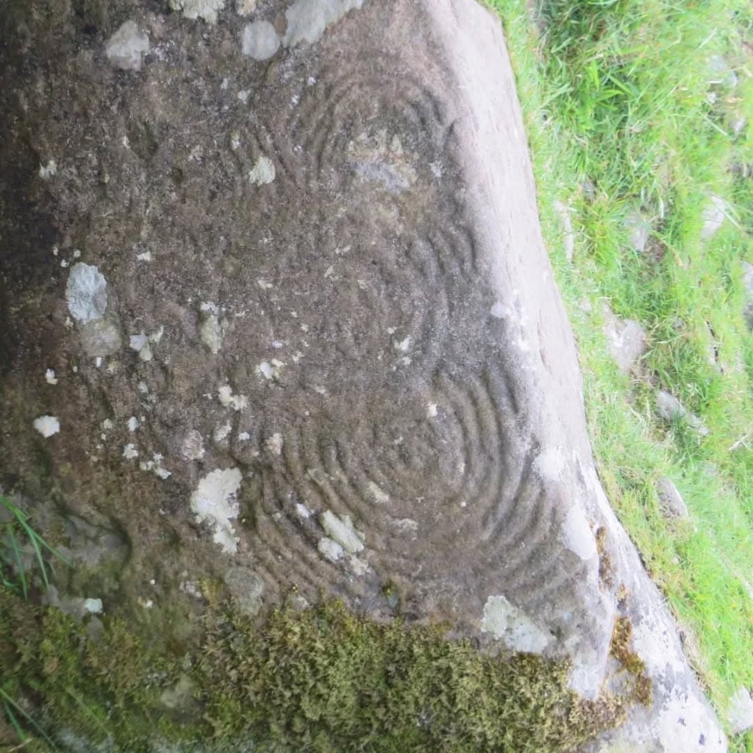 Spiral carvings cut into a weathered stone at the Loughcrew Neolithic complex