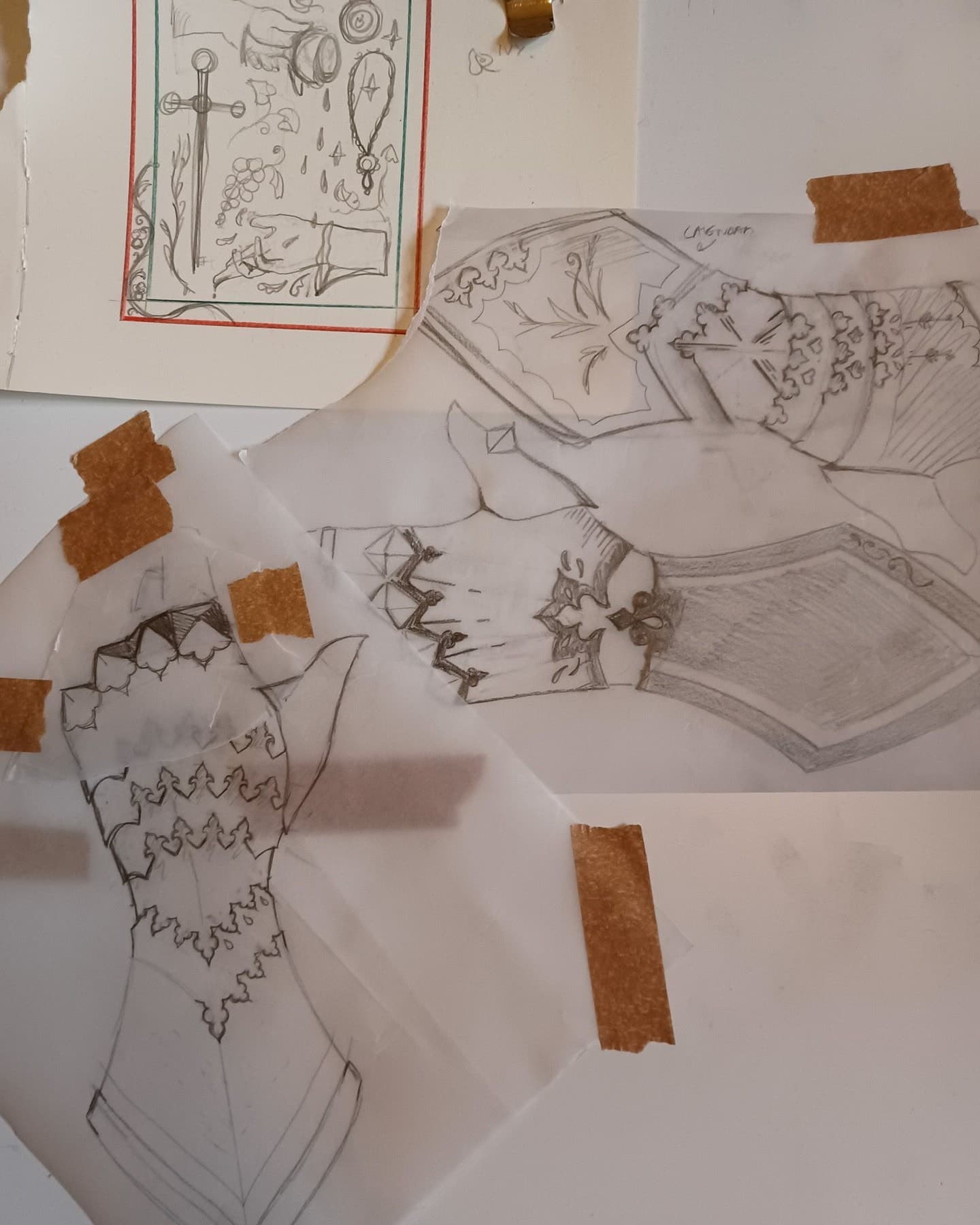 Designs worked out in pencil and taped to the desk, before any lino is cut.