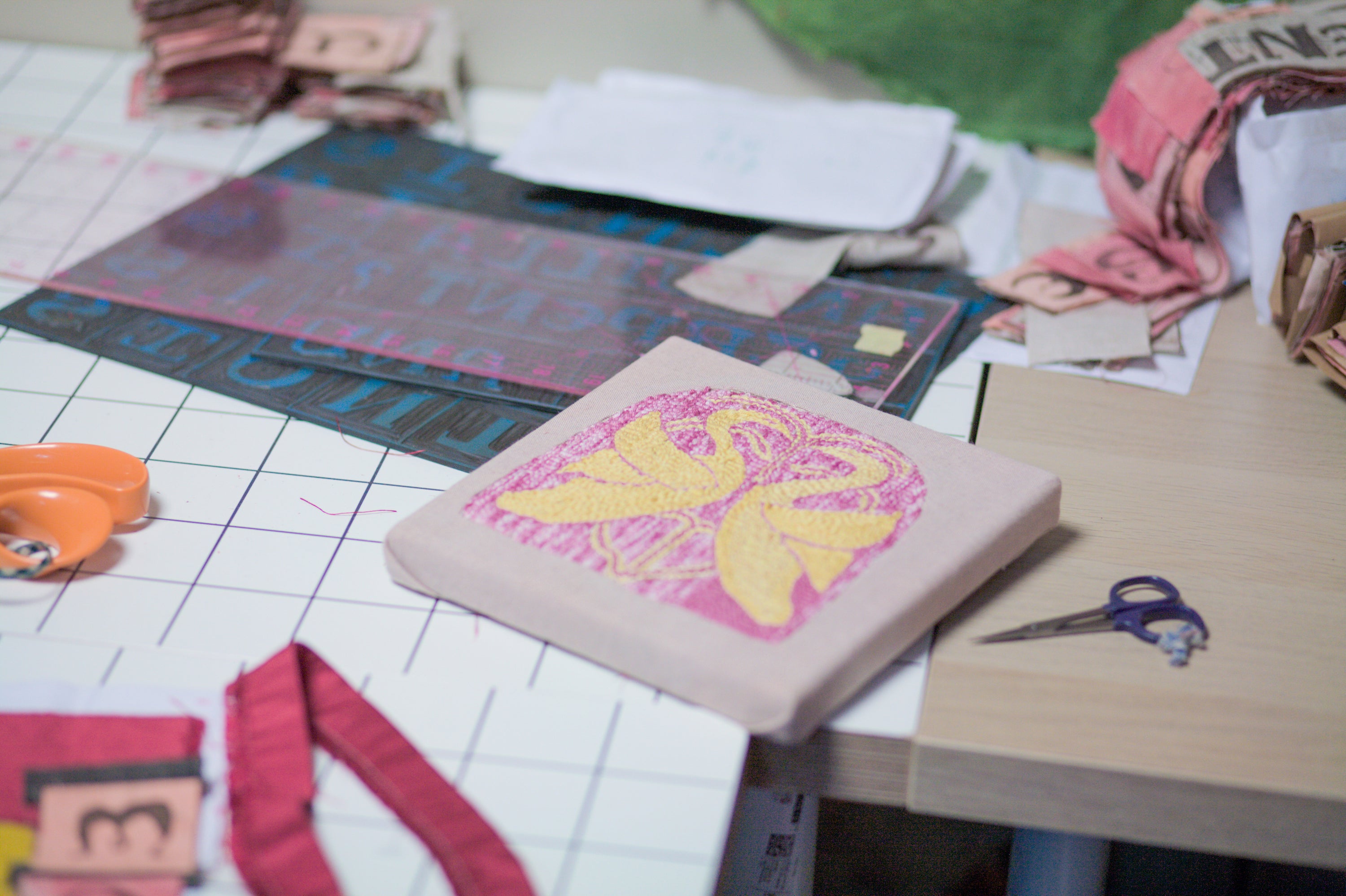 Molly Lester's hand-embroidered hanging in her studio, a folkloric narrative in colour