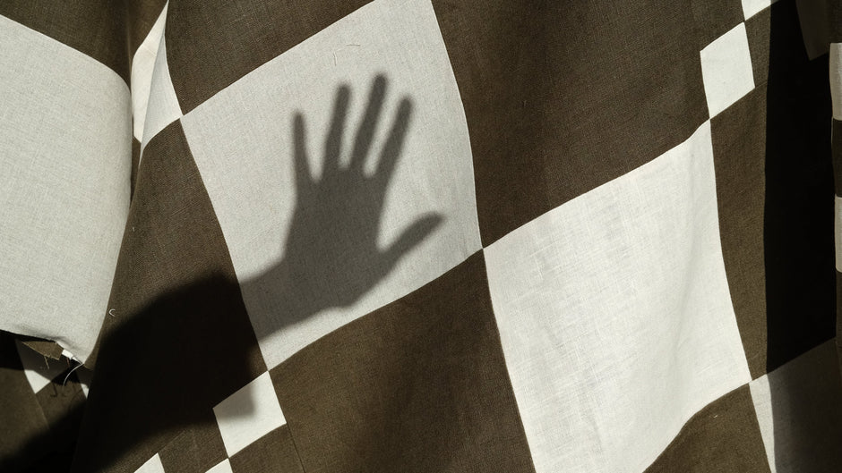 Checkered fabric with a hand casting a shadow on it