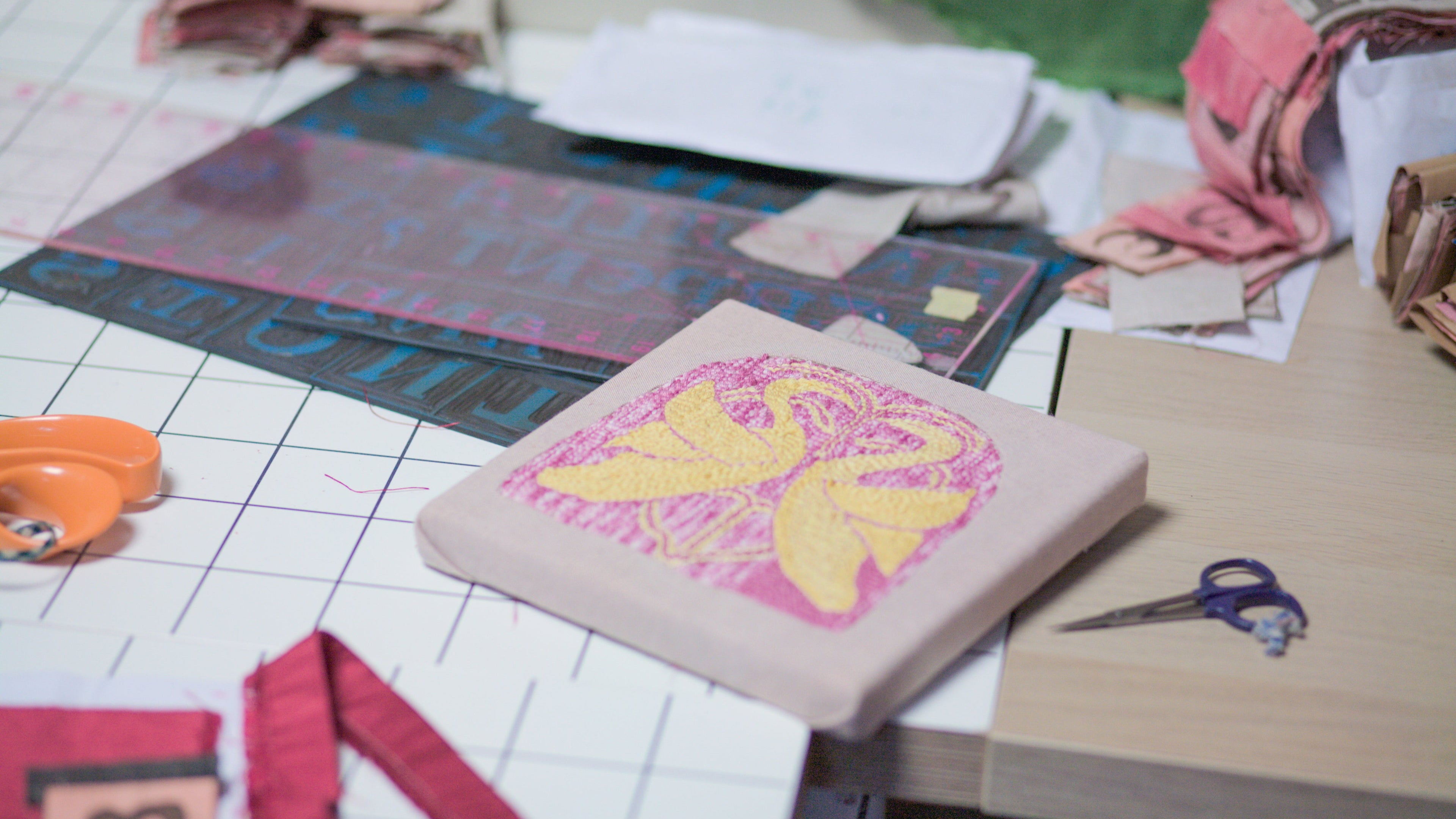 Artistic workspace with a canvas, scissors, and colorful materials on a table.