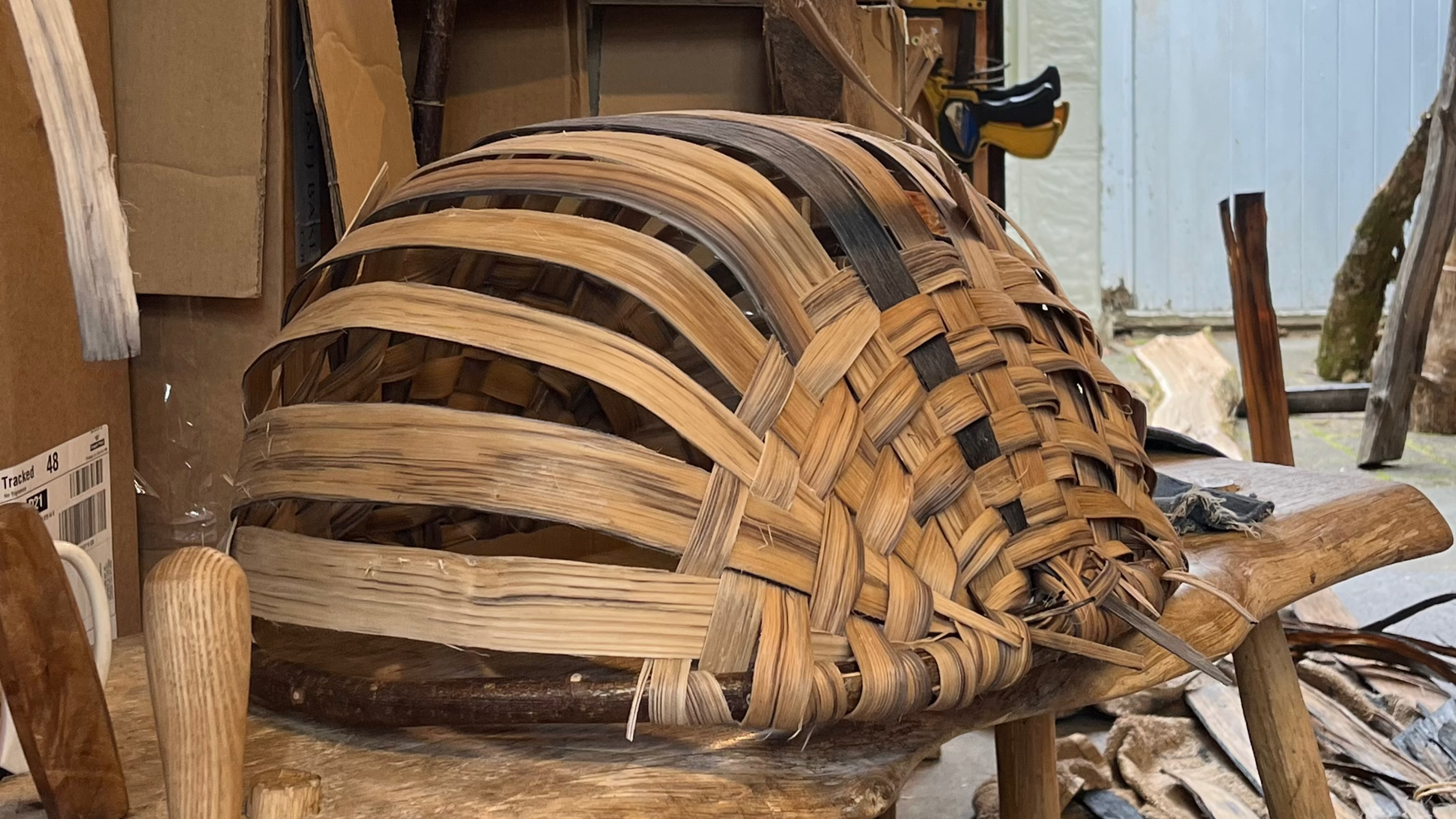 Woven basket on a wooden stool in a workshop setting