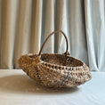 Load image into Gallery viewer, Woven basket with a handle on a light surface with curtains in the background
