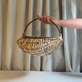 Load image into Gallery viewer, Hand holding a woven basket against a neutral curtain background
