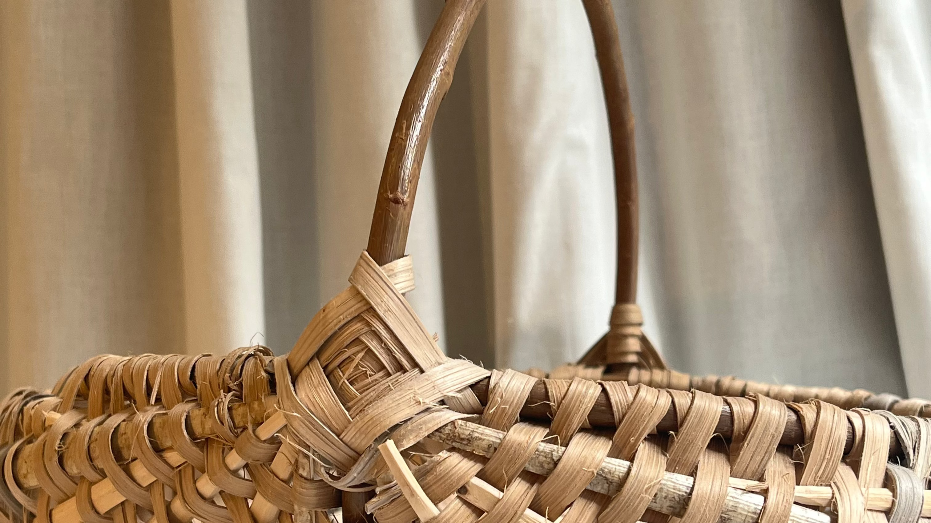 Woven basket with a handle on a neutral background