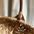 Load image into Gallery viewer, Close-up of a woven basket with a handle against a neutral background
