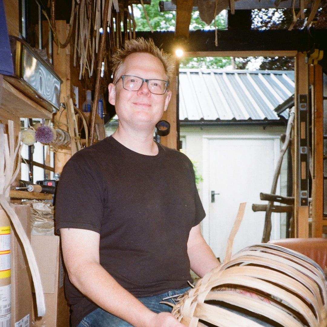 Person working on a wooden object in a workshop